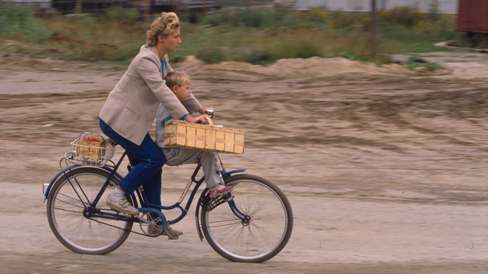 Wir sehen eine Frau mit Kind auf dem Fahrrad. 