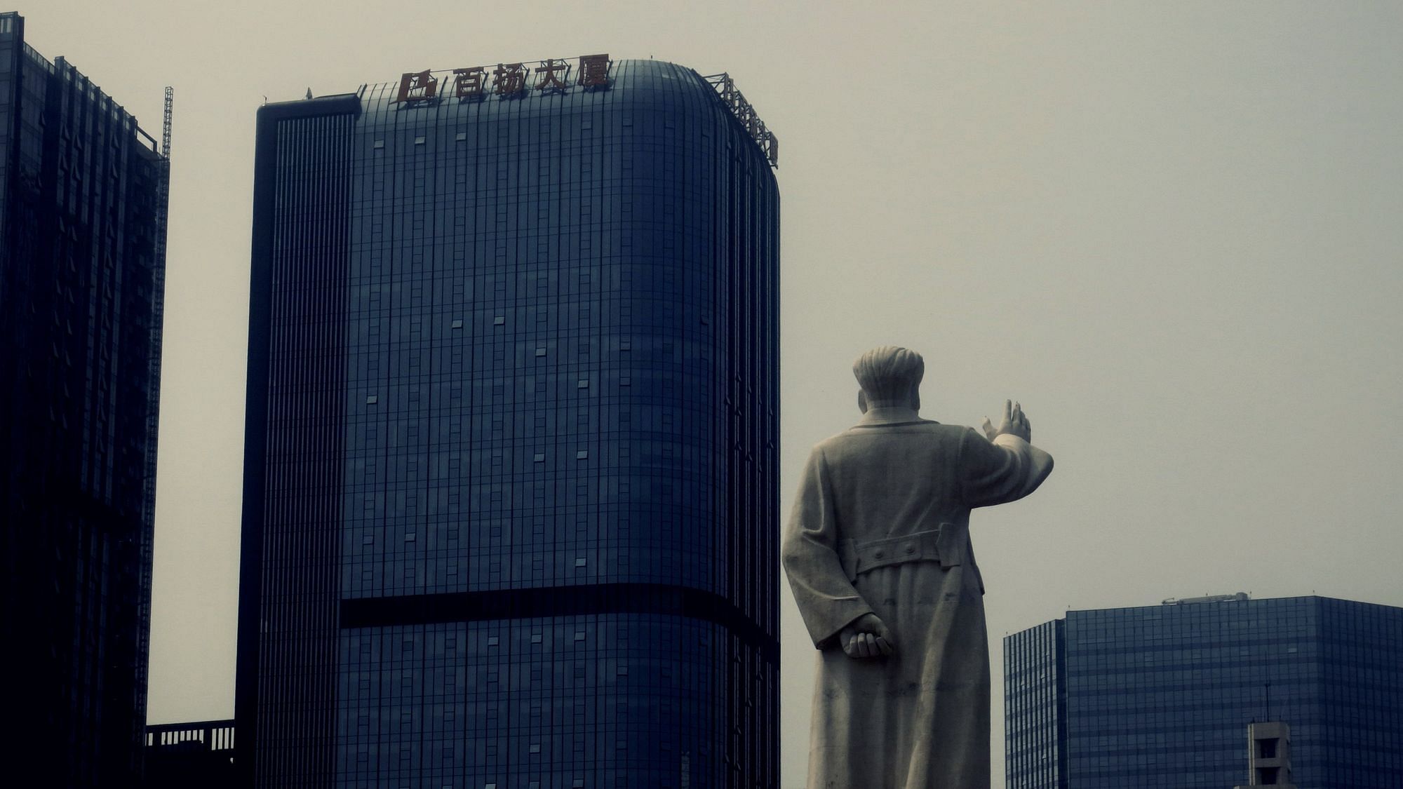 Eine Statue von Mao Zedong ist zwischen Hochhäusern der Stadt Chengdu, China zu sehen.