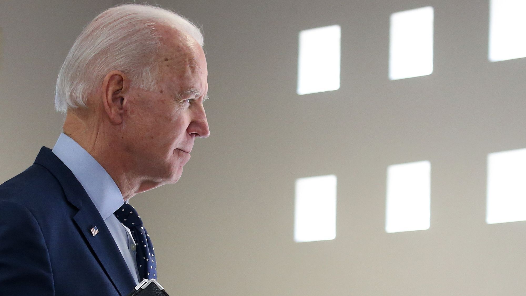 Wir sehen Joe Biden, seitlich fotografiert in einem hellen Bild, wie er nachdenklich aussieht. 