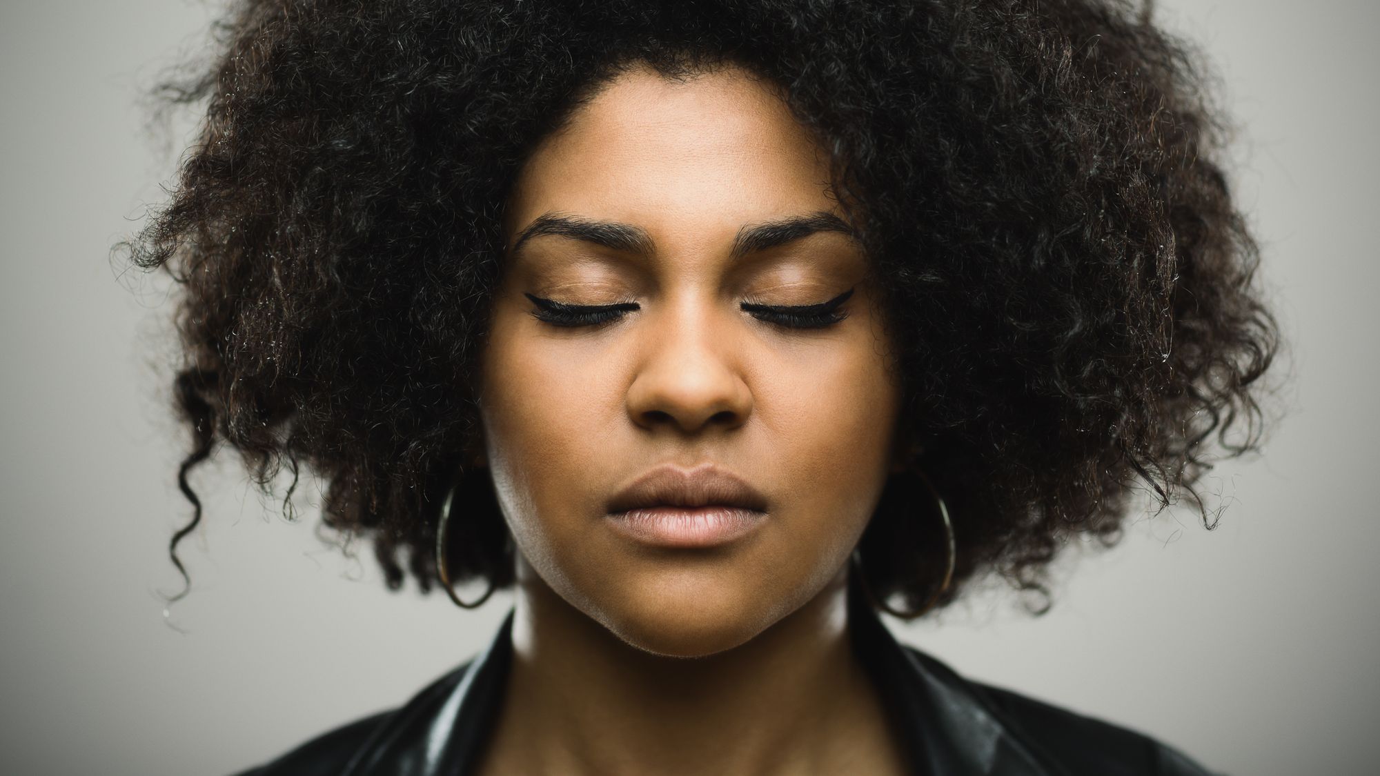 Porträt einer Frau, die mit geschlossenen Augen meditiert.