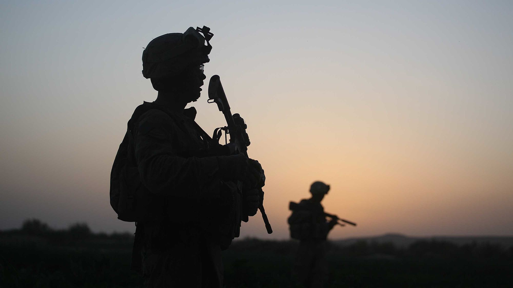 Wir sehen zwei Soldaten im Gegenlicht, im Hintergrund afghanische Landschaft in der Abendsonne.