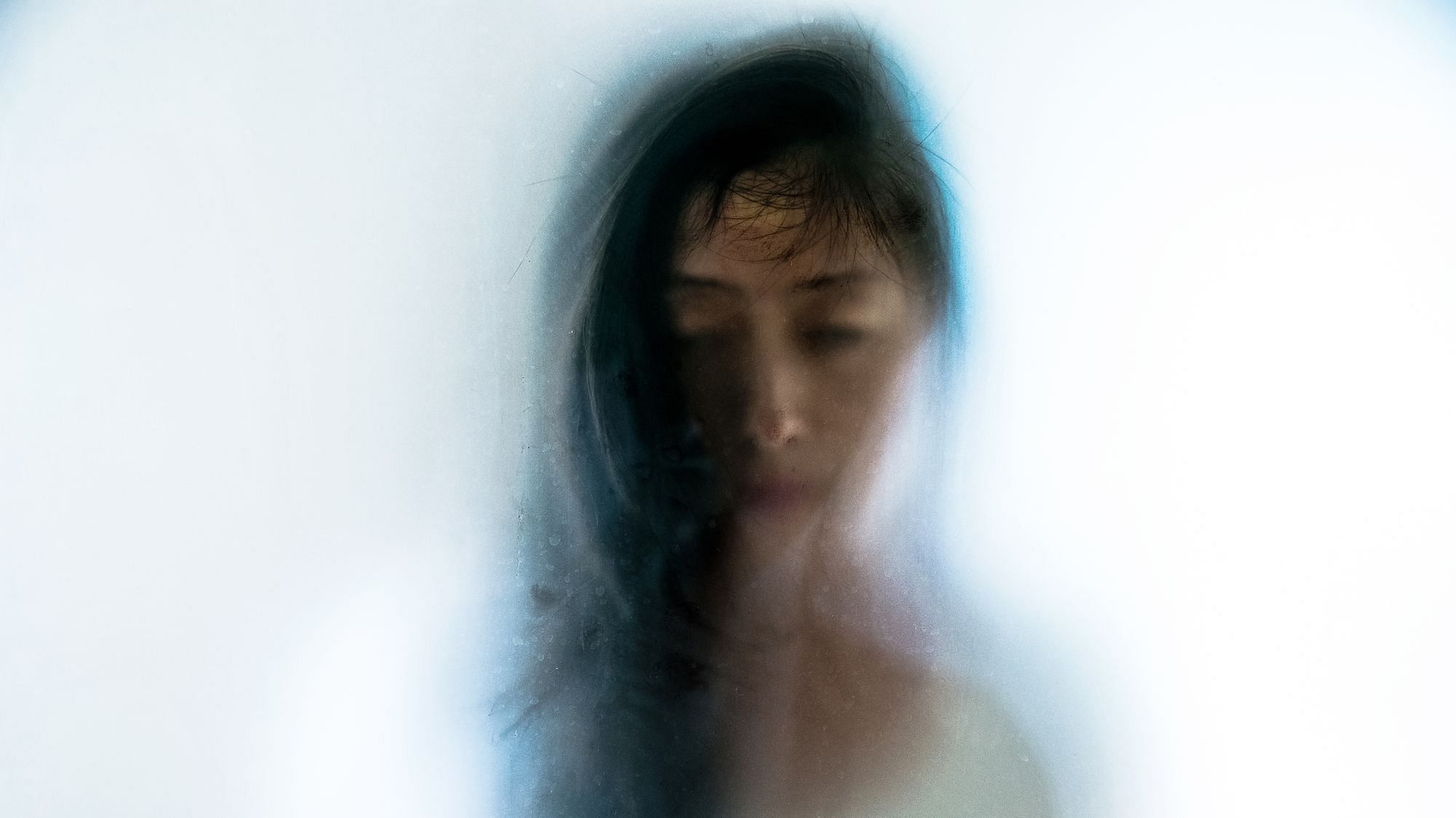 Eine Frau spähte durch eine Milchglasscheibe