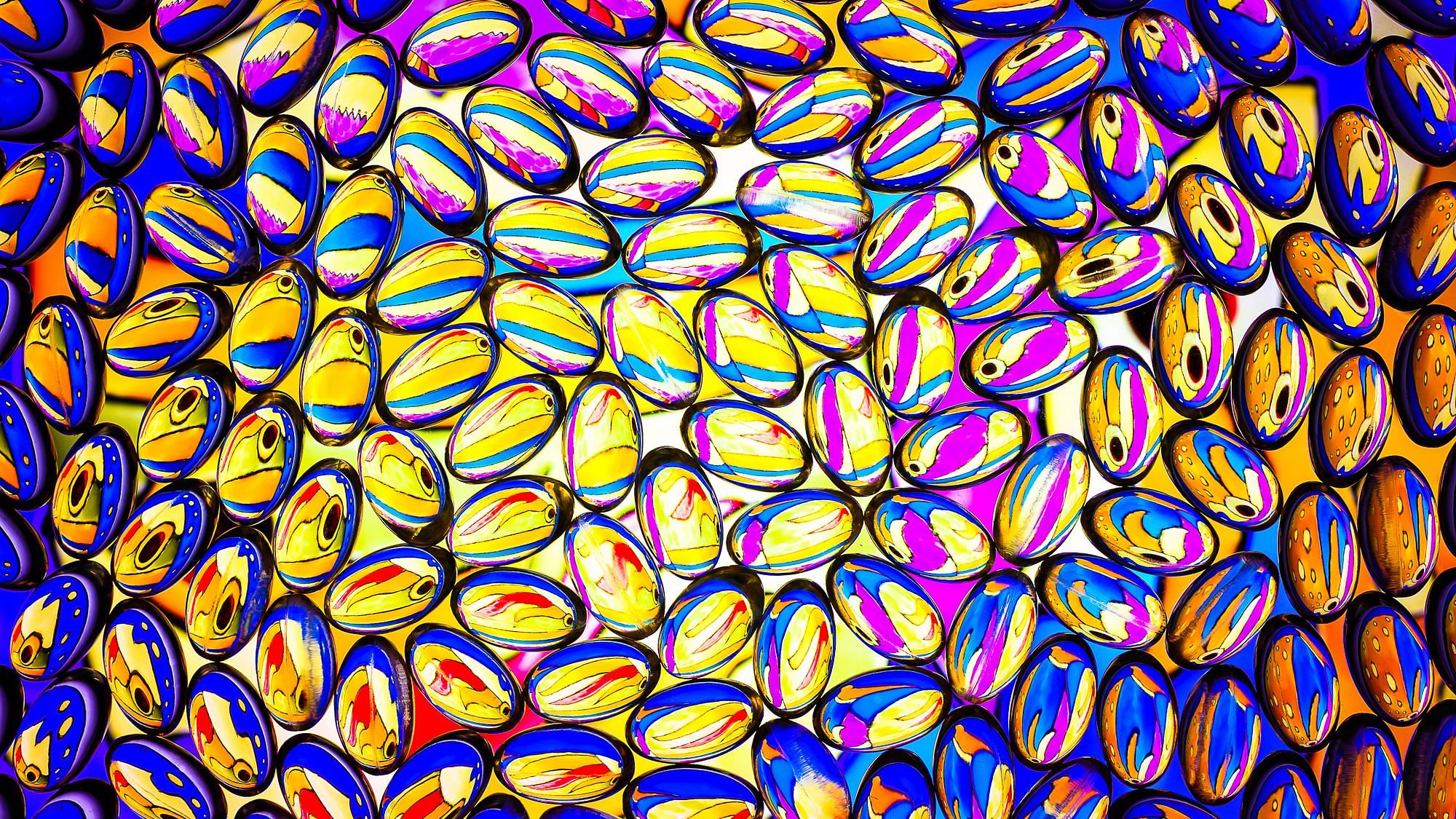 Gelblich-durchsichtige Vitamin D Pillen werden von hinten beleuchtet.