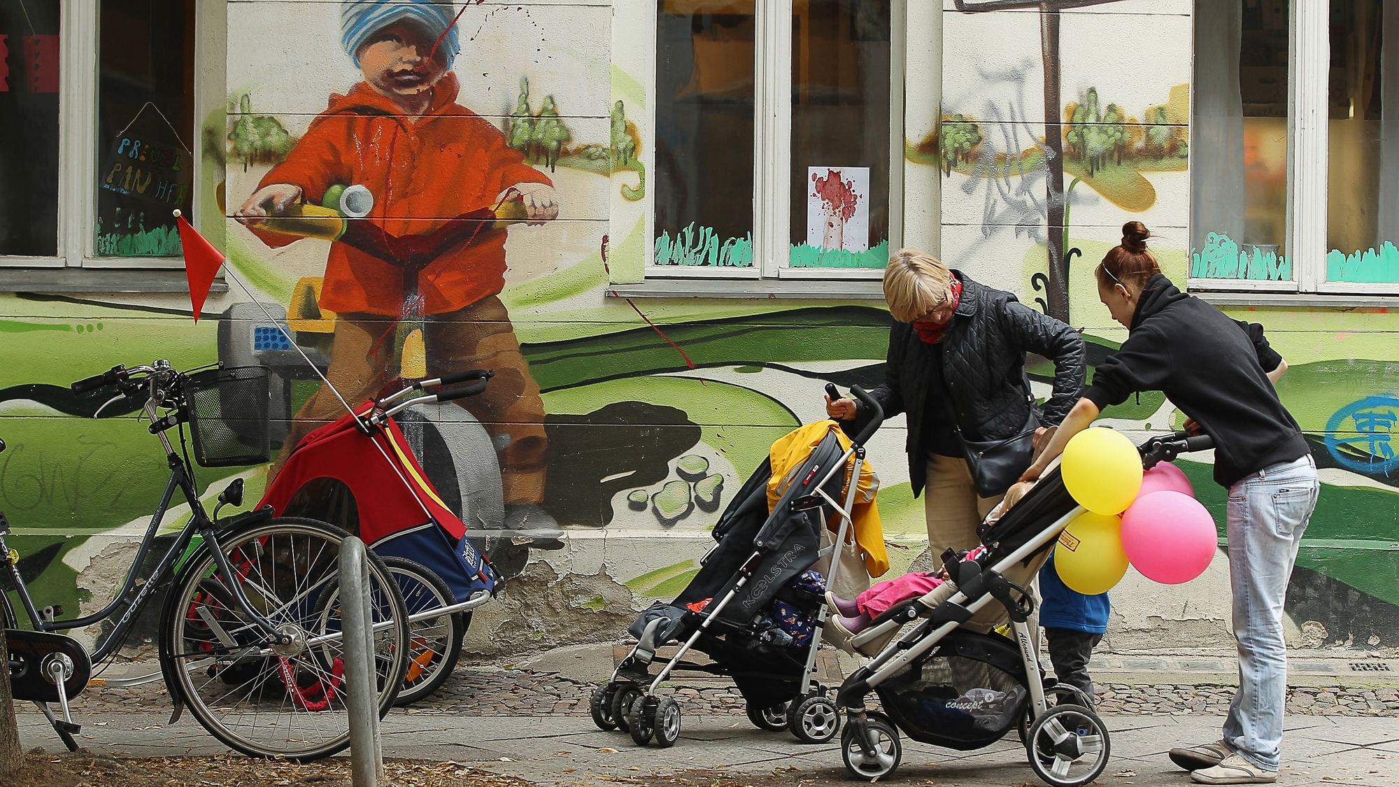  Zwei Frauen mit Kinderwagen gehen am 17. Juli 2012 in Berlin an einer Kindertagesstätte (Kita) vorbei.