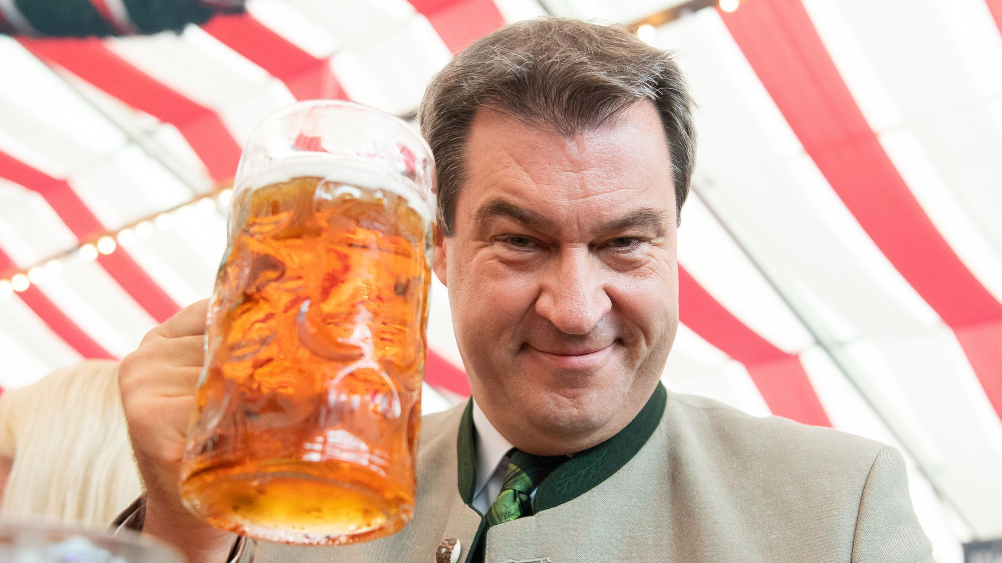 Markus Söder prostet uns mit einer Maß Bier zu.