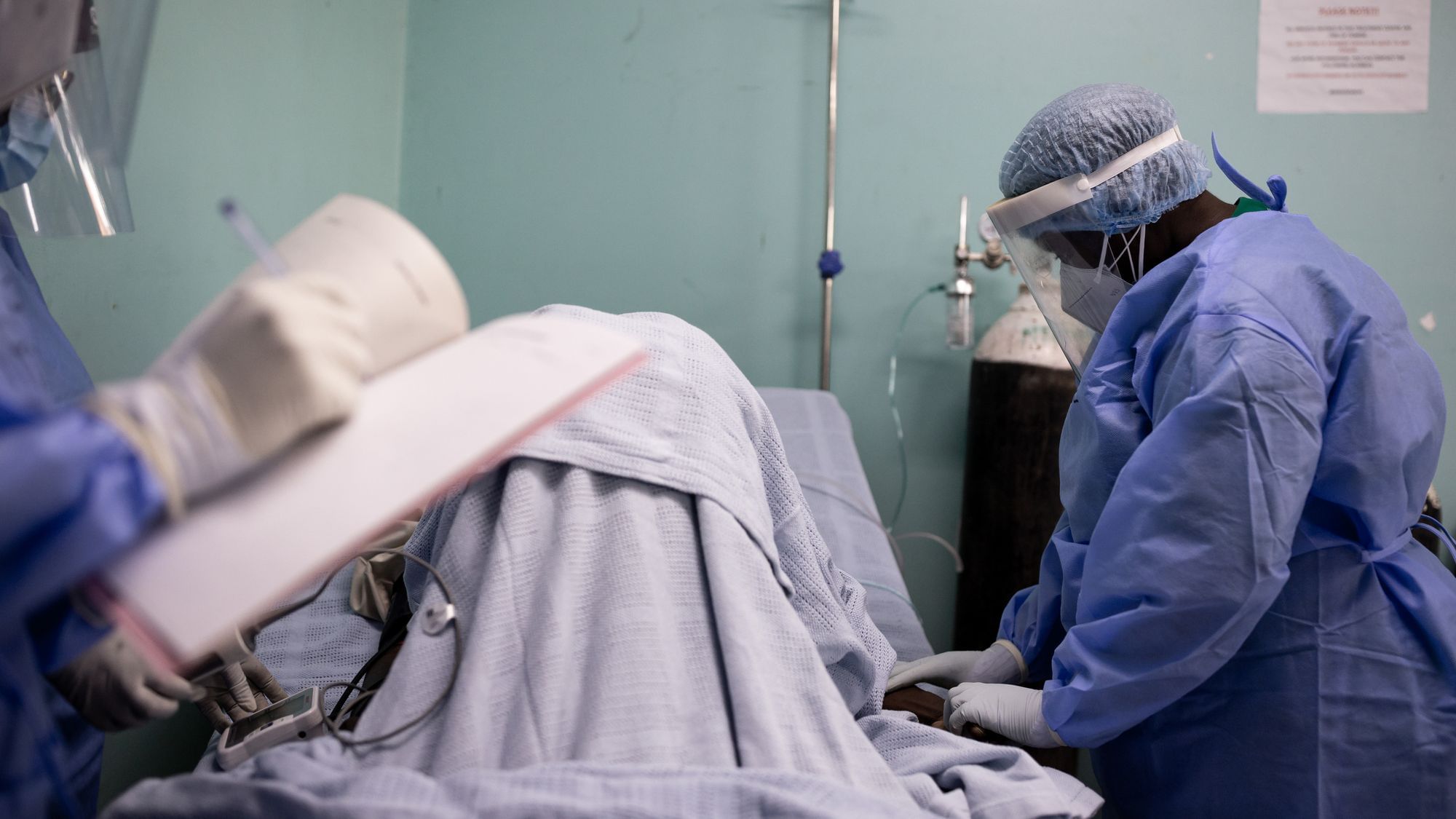 Medzinisches Personal kümmert sich um ein:e Patient:in in Kampala.