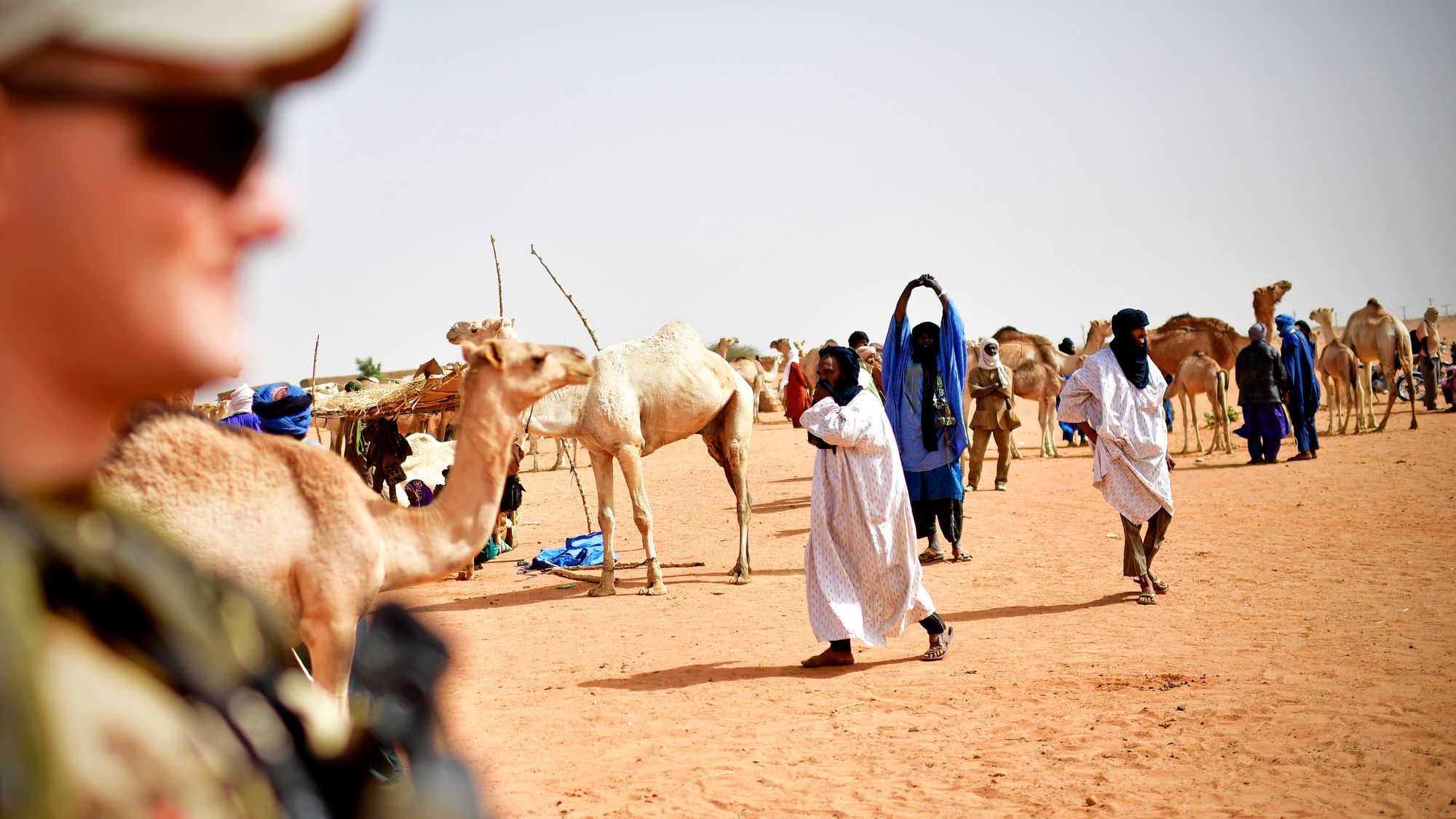Links in Bokeh ein deutscher Soldat, dahinter der Viehmarkt in der Peripherie von Gao