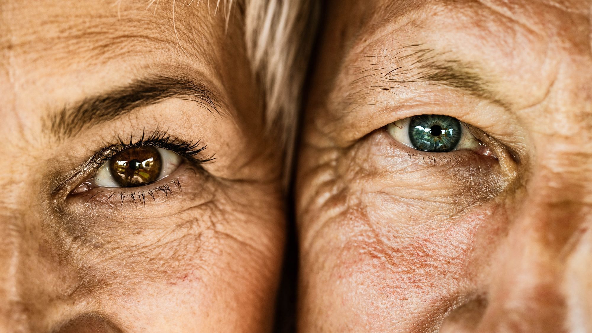 Nahaufnahme eines Mannes und einer Frau mit Falten und strahlend blauen Augen.