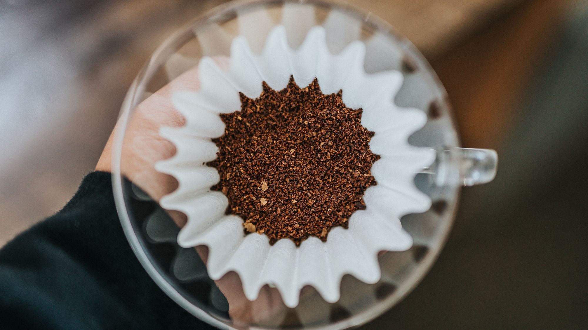 Frisch gemahlener Kaffee mit einem Papierfilter in einem Glastrichter
