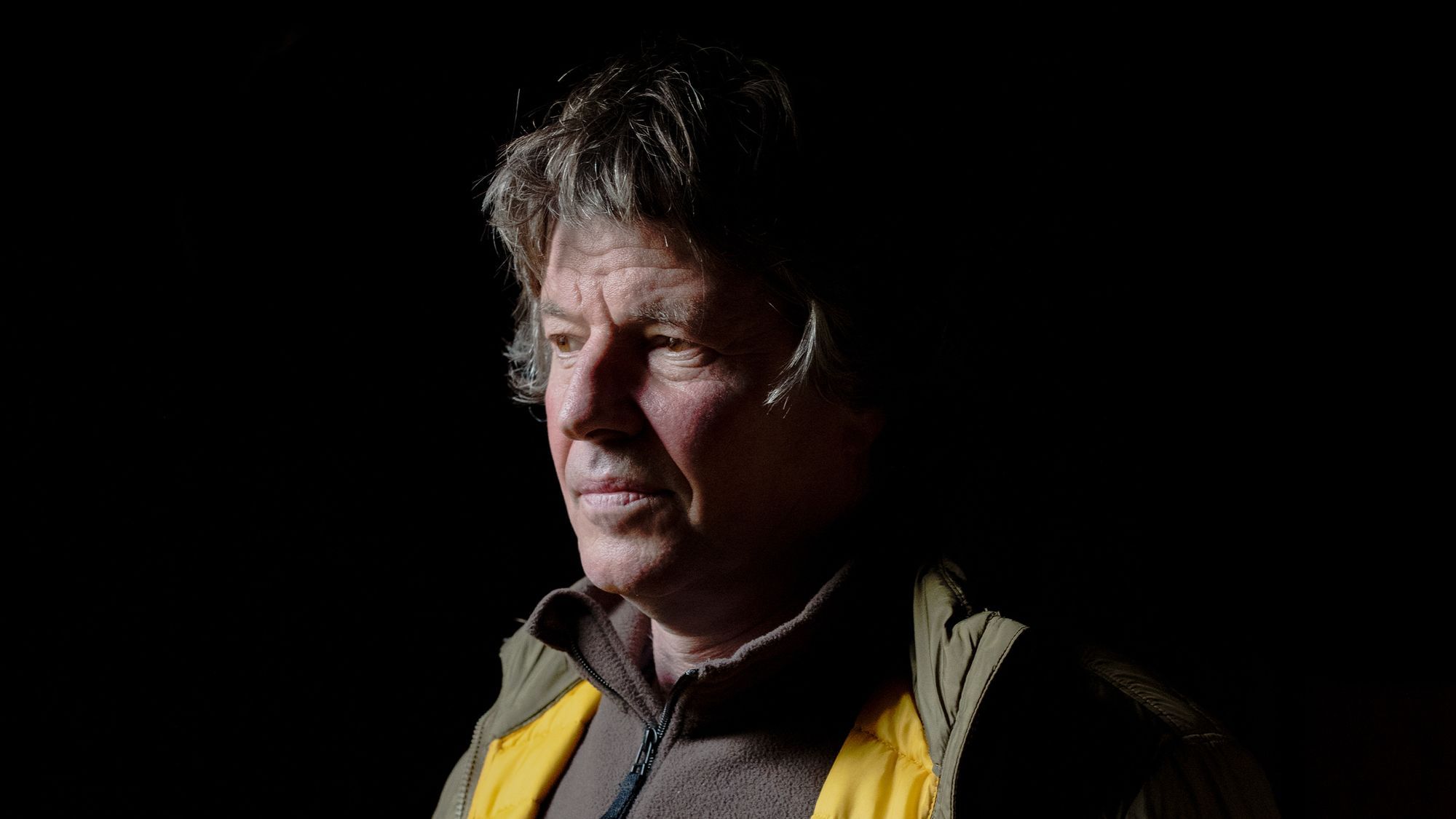 Eckard Heukamp steht in einem dunklen Raum, sein Preiviertel-Profil ist zu sehen. Licht scheint ihm ins Gesicht. 