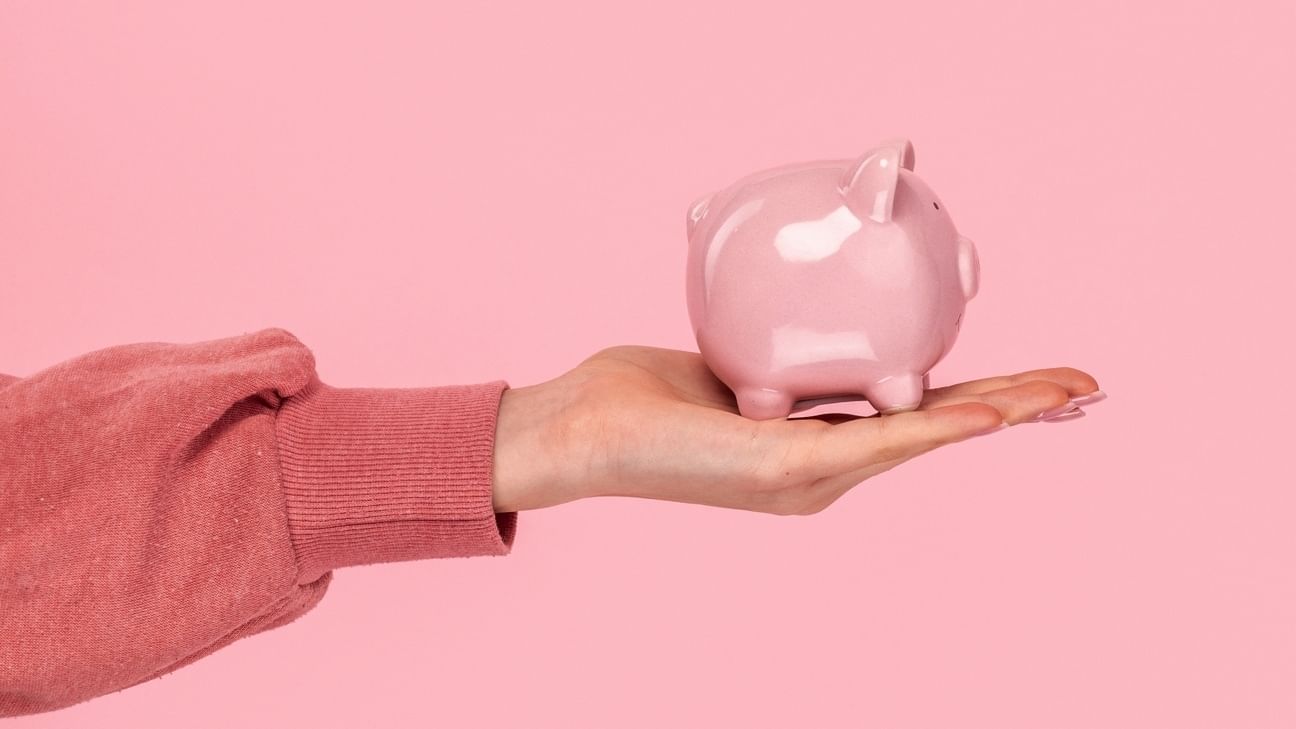 Eine Frau zeigt ein Sparschwein.