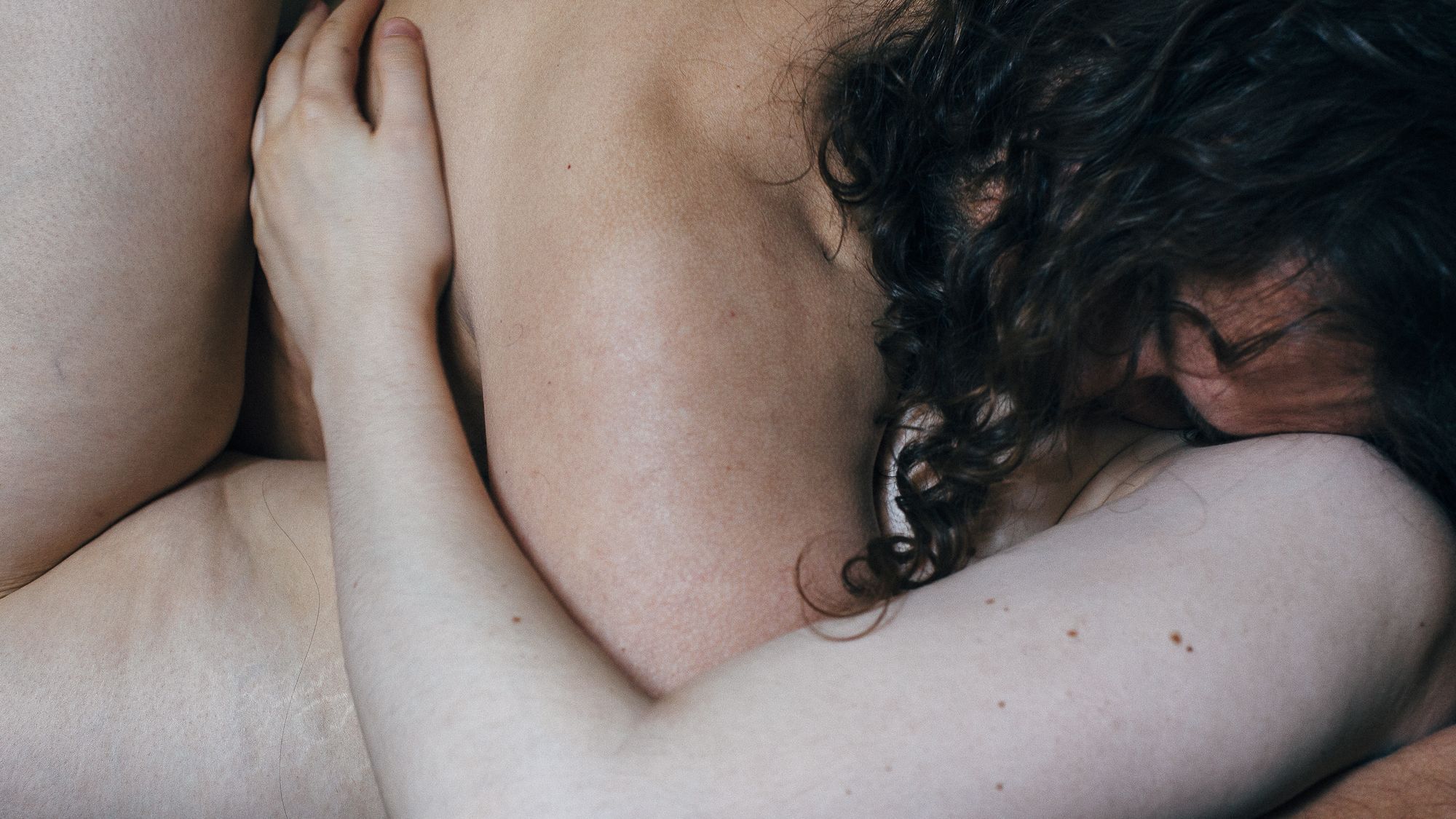 Zwei Menschen beim Kuscheln, man sieht nackte Haut