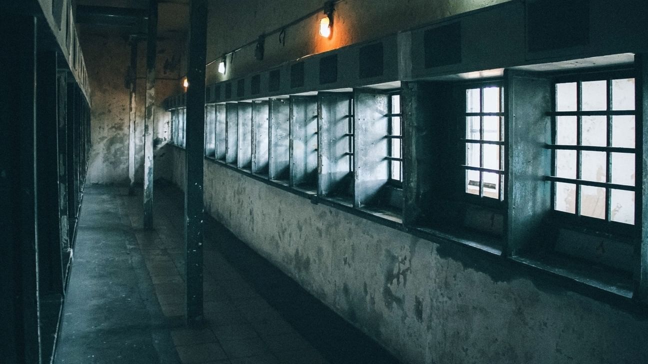 Graue Betonwände, Fenster mit Gittern. Das Bild zeigt einen Gang in einem ehemaligen Teheraner Gefängnis.