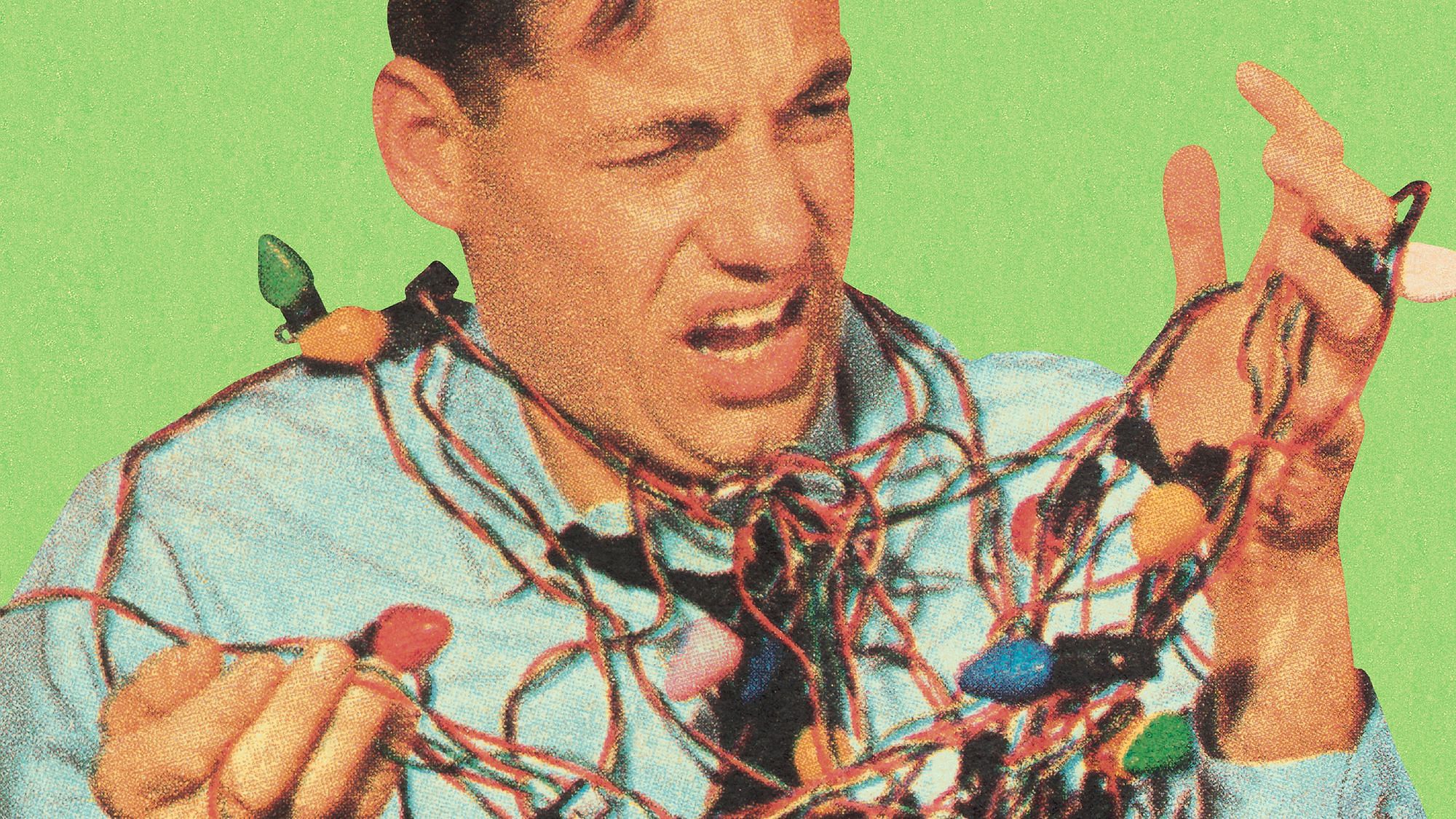 Ein Mann verheddert sich in einer Lichterkette