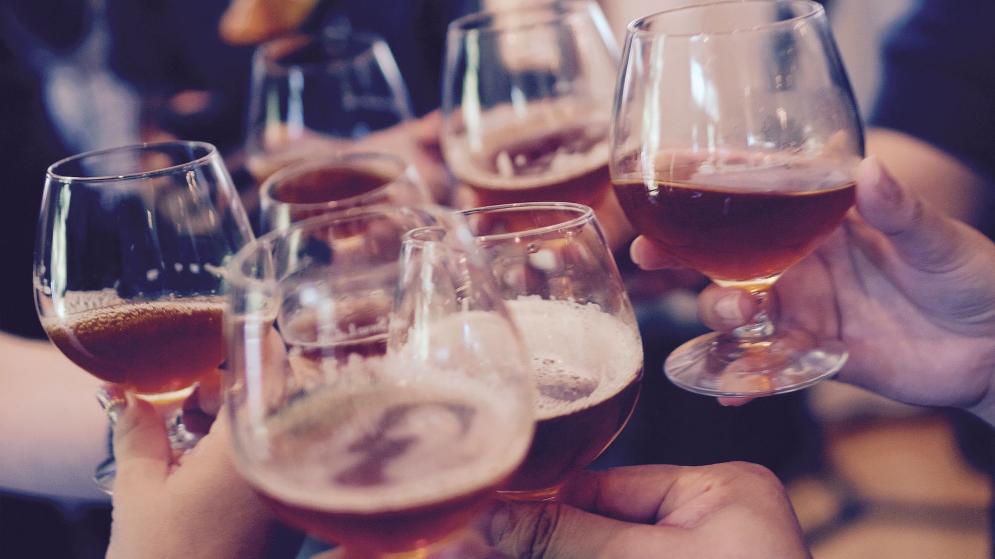 Mehrere Menschen stoßen mit Bier an.