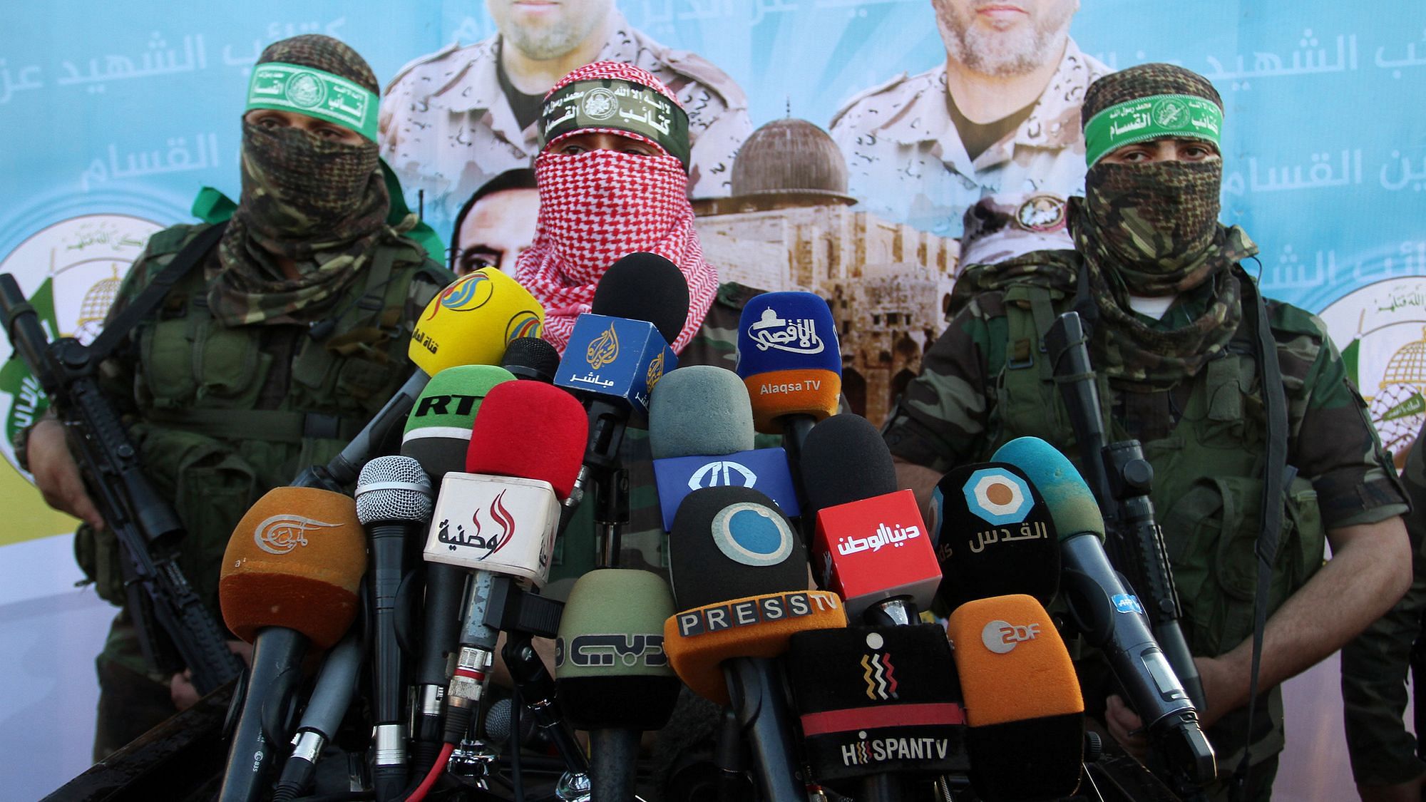 Drei Hamas-Anhänger geben eine Pressekonferenz. Sie sind vermummt und tragen grüne Stirnbänder.