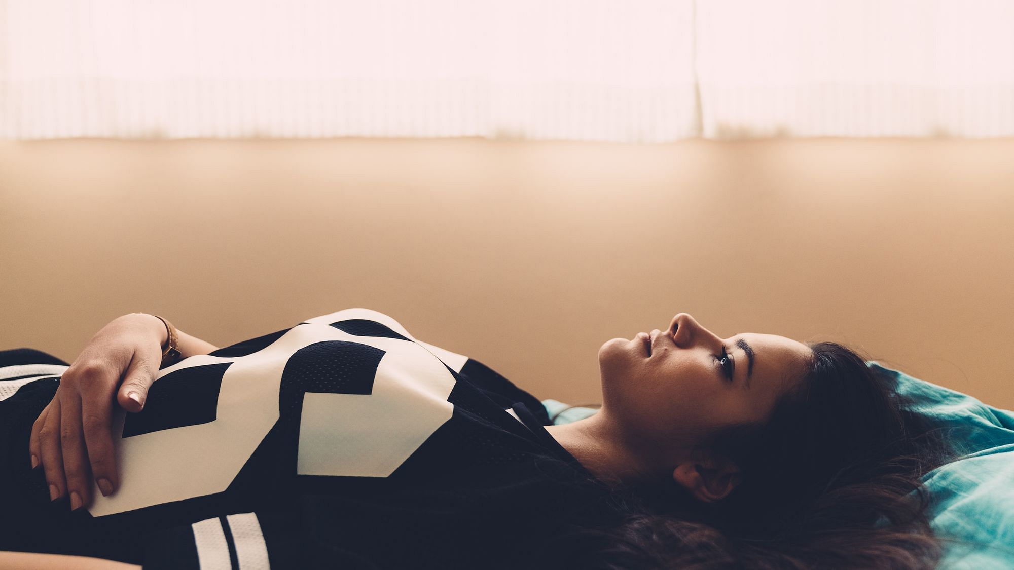 Eine Jugendliche liegt auf ihrem Bett und guckt an die Decke. 