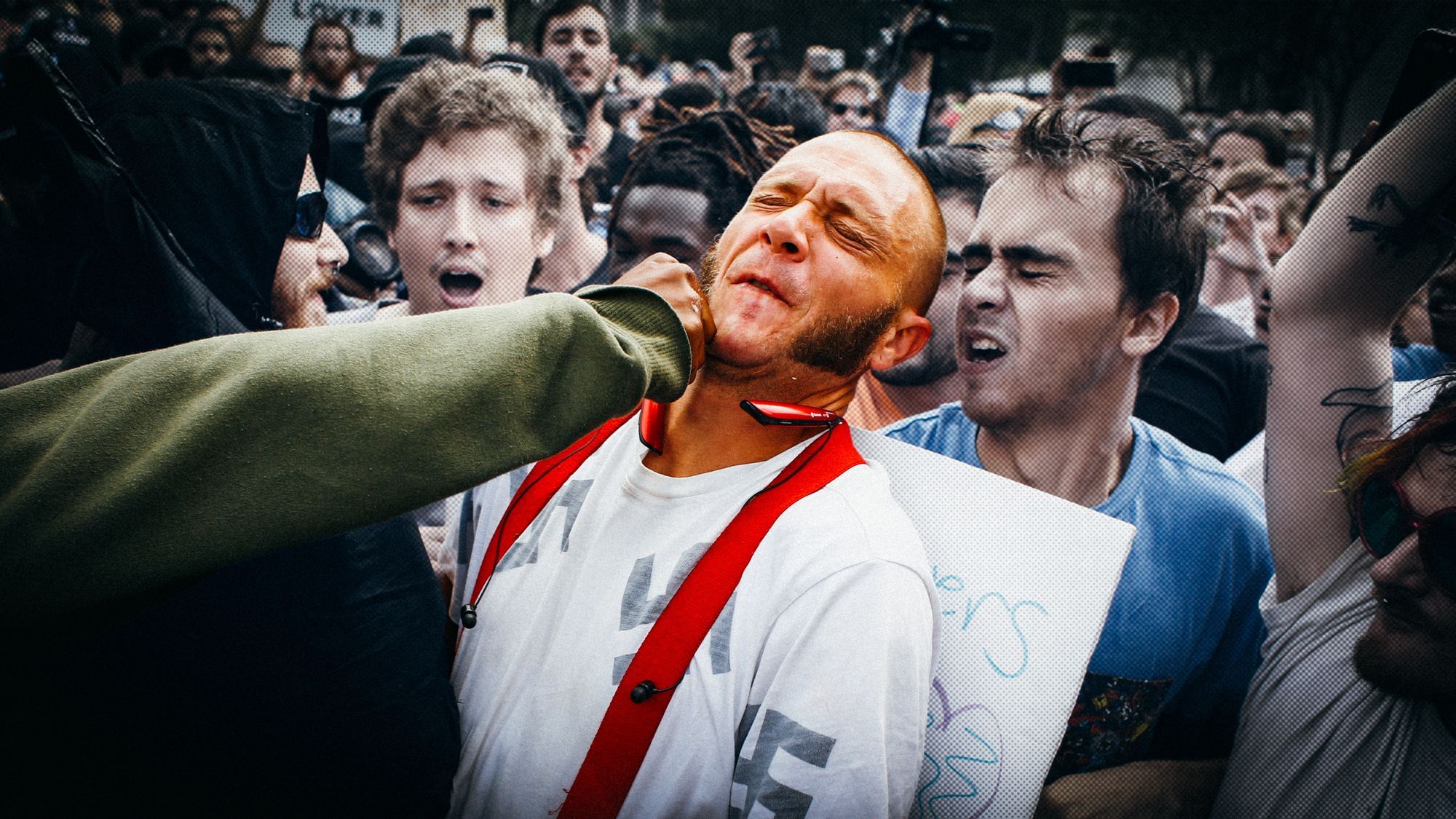 Einem Neonazi wird mit der Faust ins Gesicht geschlagen. Er trägt kurze Haare, einen Backenbart, rote Hosenträger und ein weißes T-Shirt, auf dem Hakenkreuze abgedruckt sind.