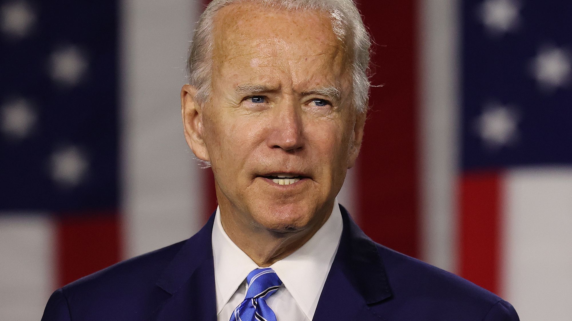US-Präsident Joe Biden steht im Anzug vor einem Mikrofon und schaut eine Mischung aus entschlossen und verzweifelt 