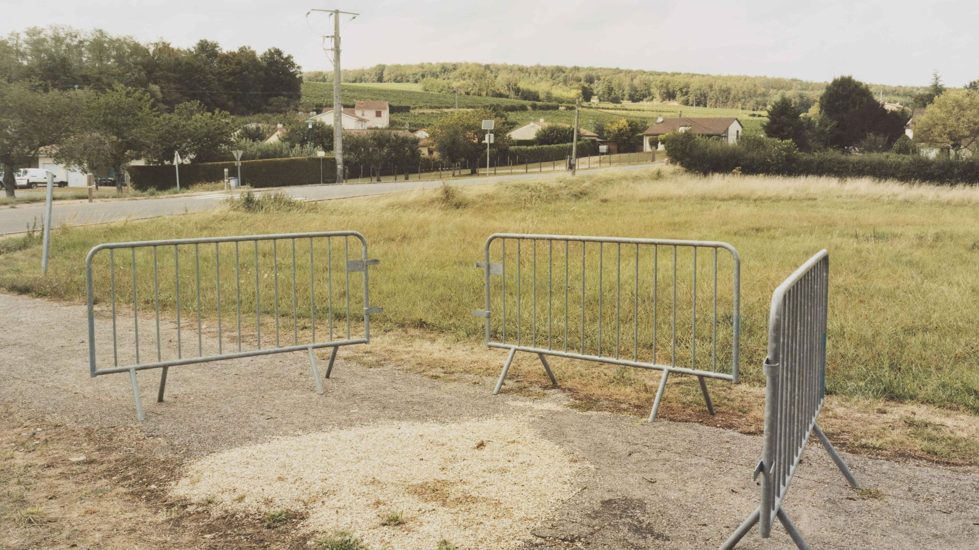 Ein Gehweg, im Hintergrund ein Dorf