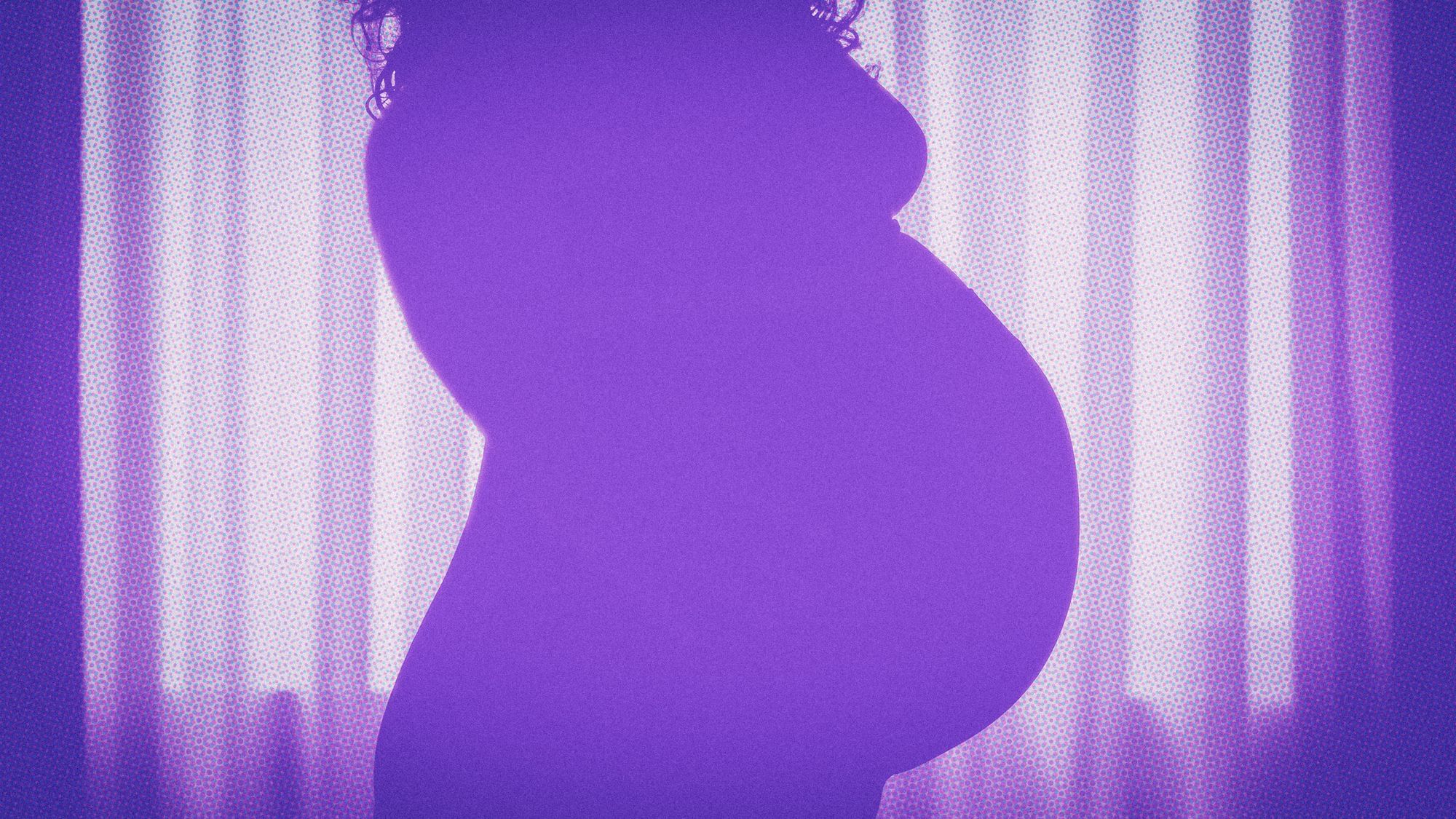 Eine schwangere Frau vor einem Vorhang. 