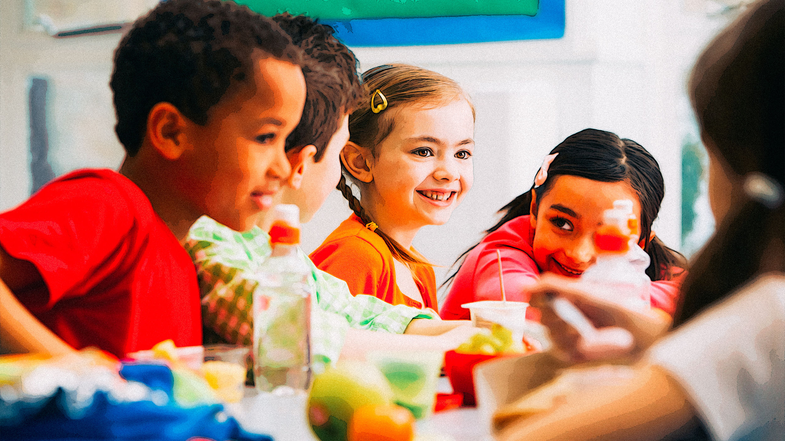 Grundschulkinder sitzen um einen Tisch beim Frühstück