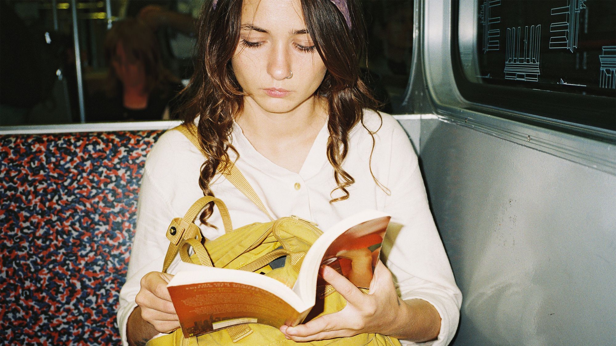 Eine Frau liest ein Buch in der U-Bahn