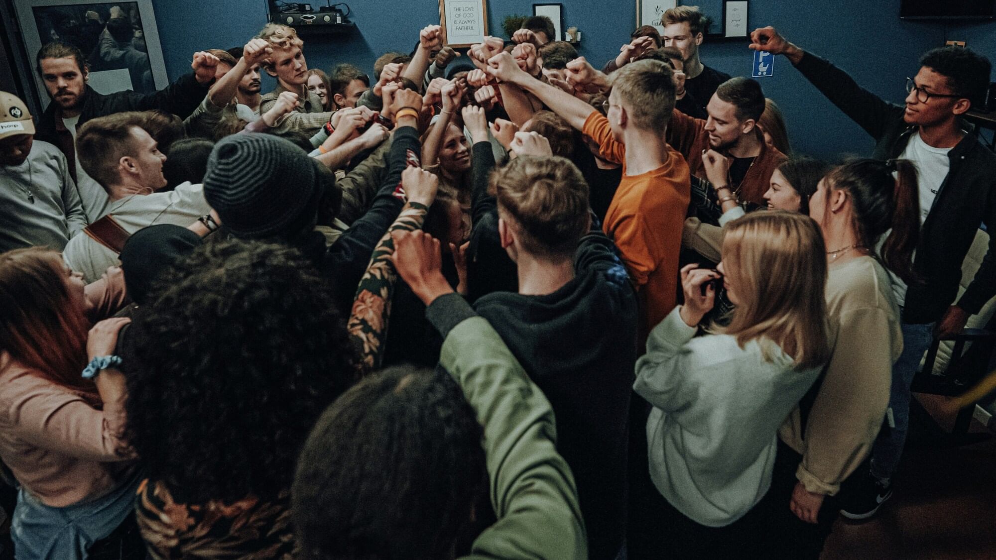 Junge Personengruppe ballt faust in der Mitte. 