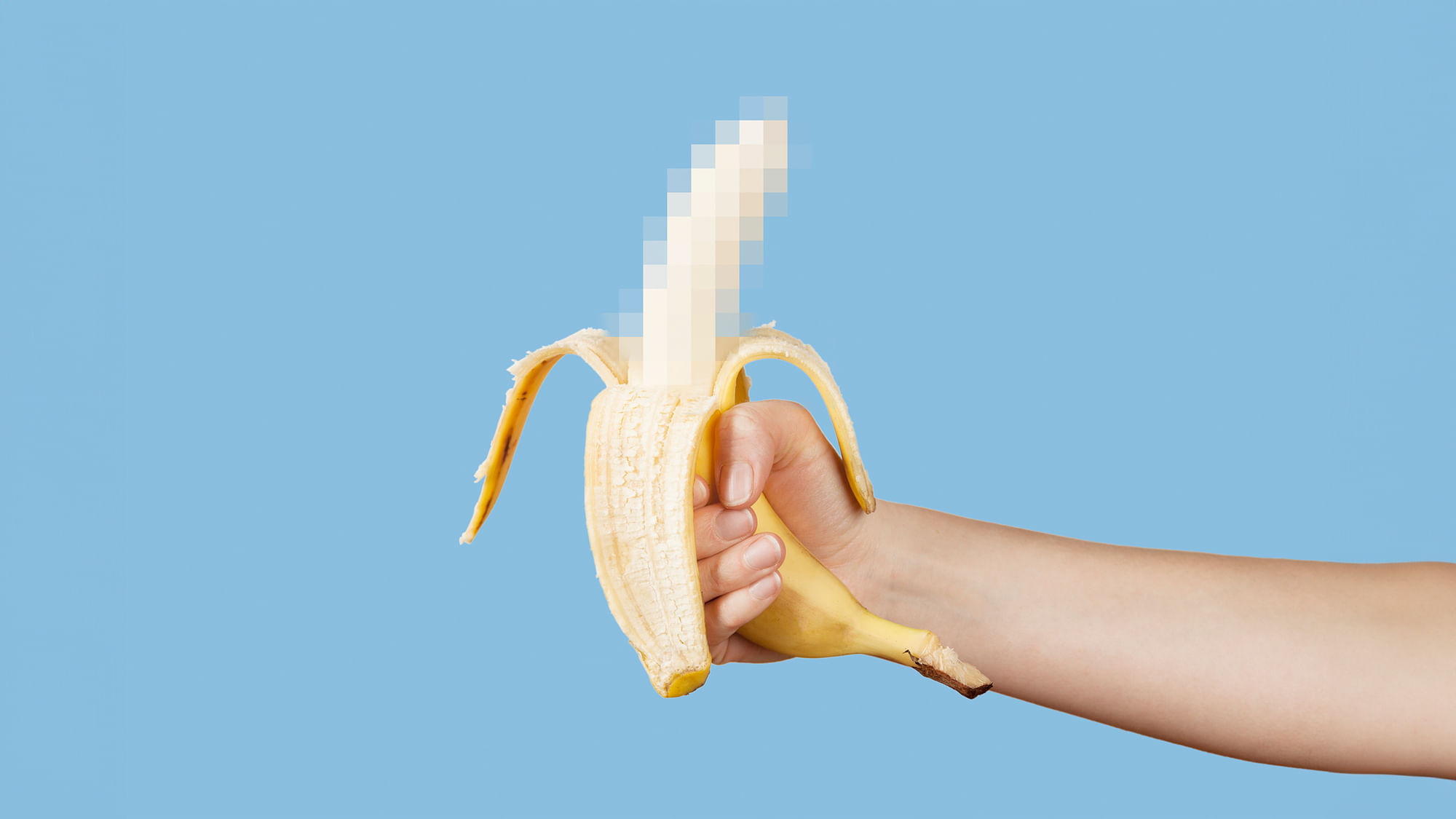 Eine Hand hält eine geschälte Banane vor blauem Grund. Der ungeschälte Teil ist zensiert.
