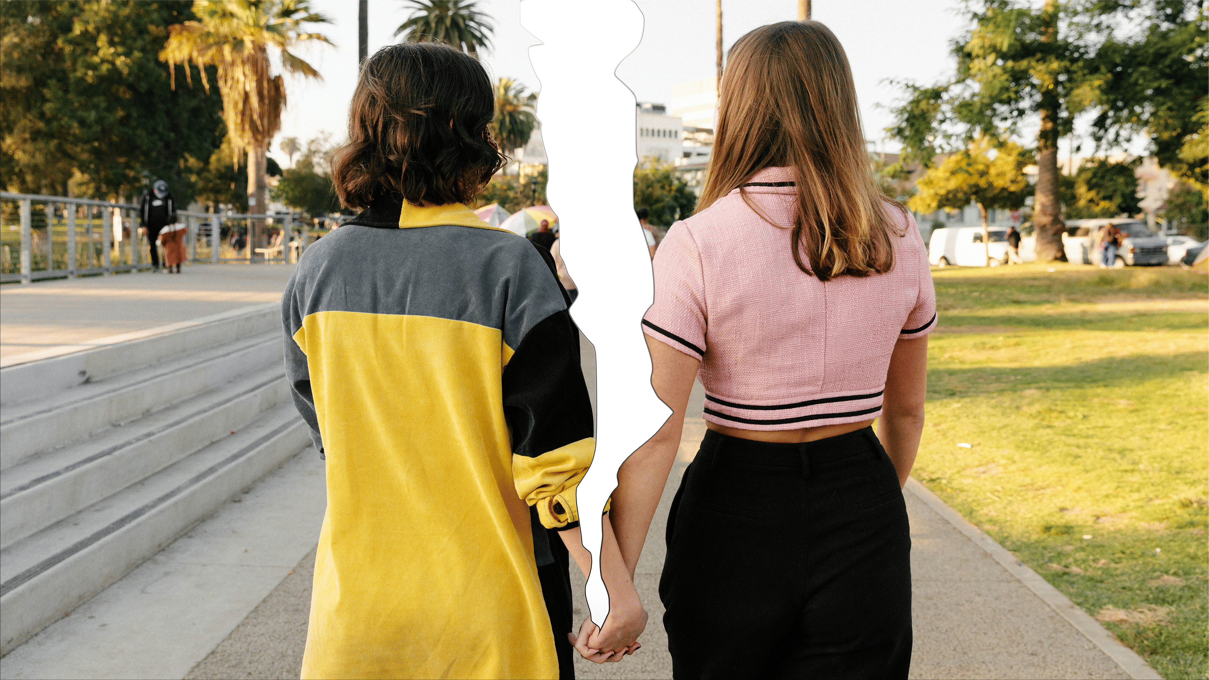 Zwei Personen im Vordergrund, Spalt der durch die Mitte geht, halten händchen