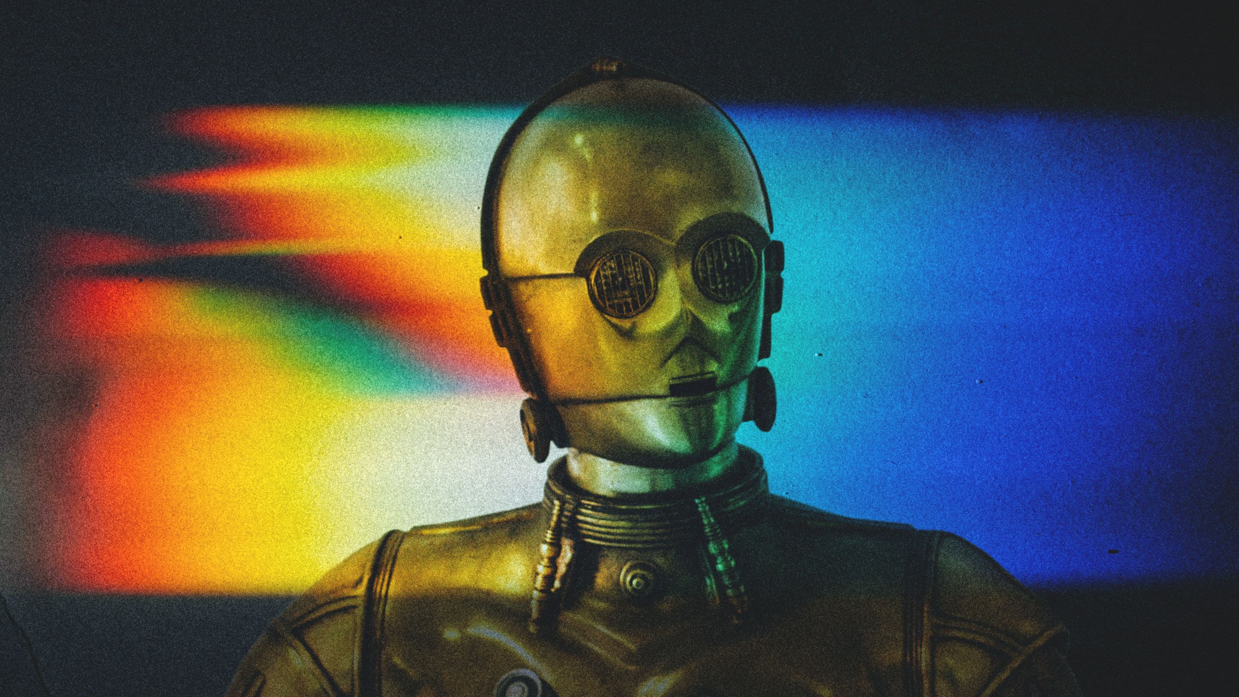 Fotomontage: Ein goldener Roboter vor einem Regenbogenhintergrund.