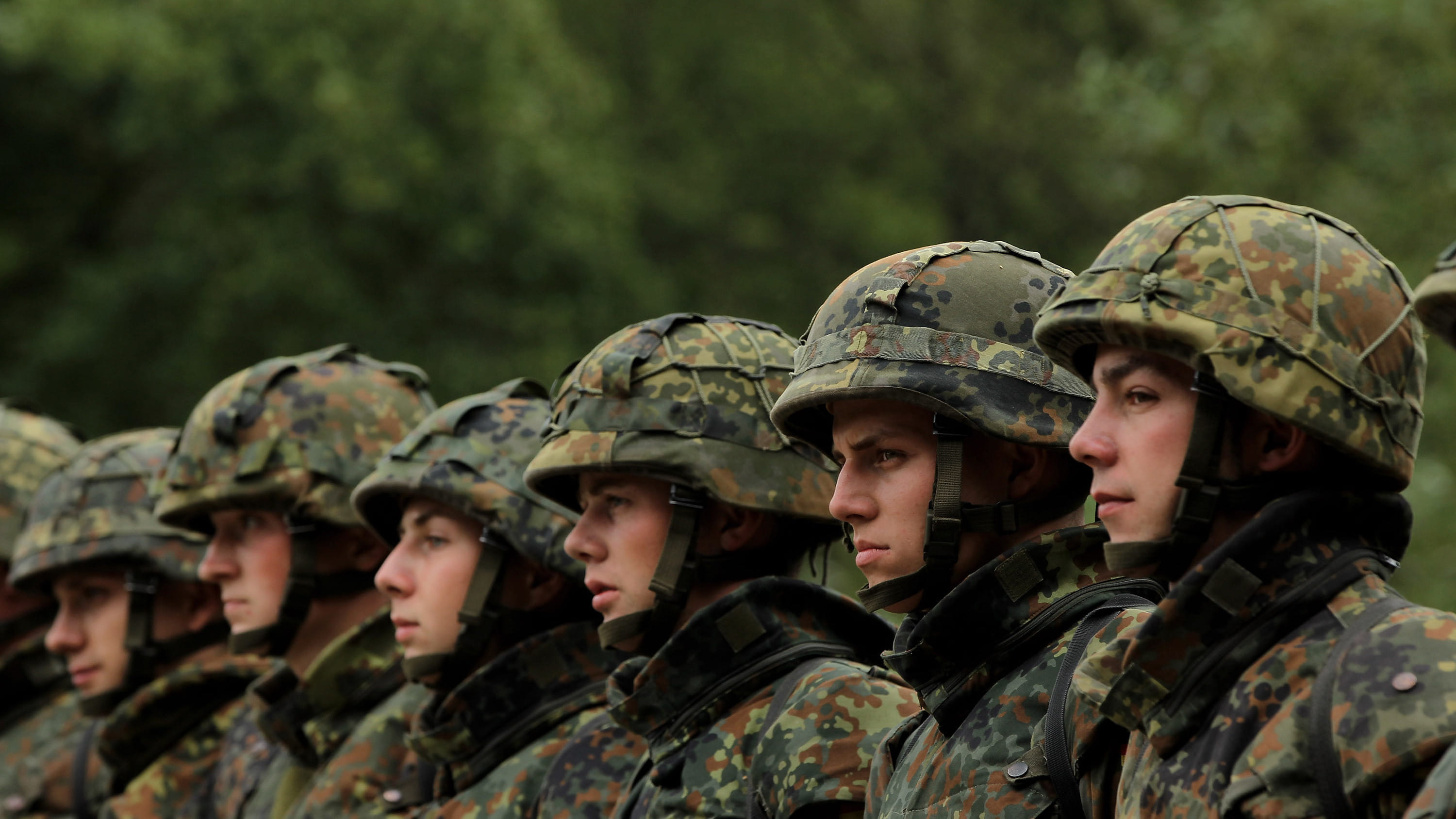 Man sieht mehrere junge Menschen in Uniform, die in einer Reihe stehen.