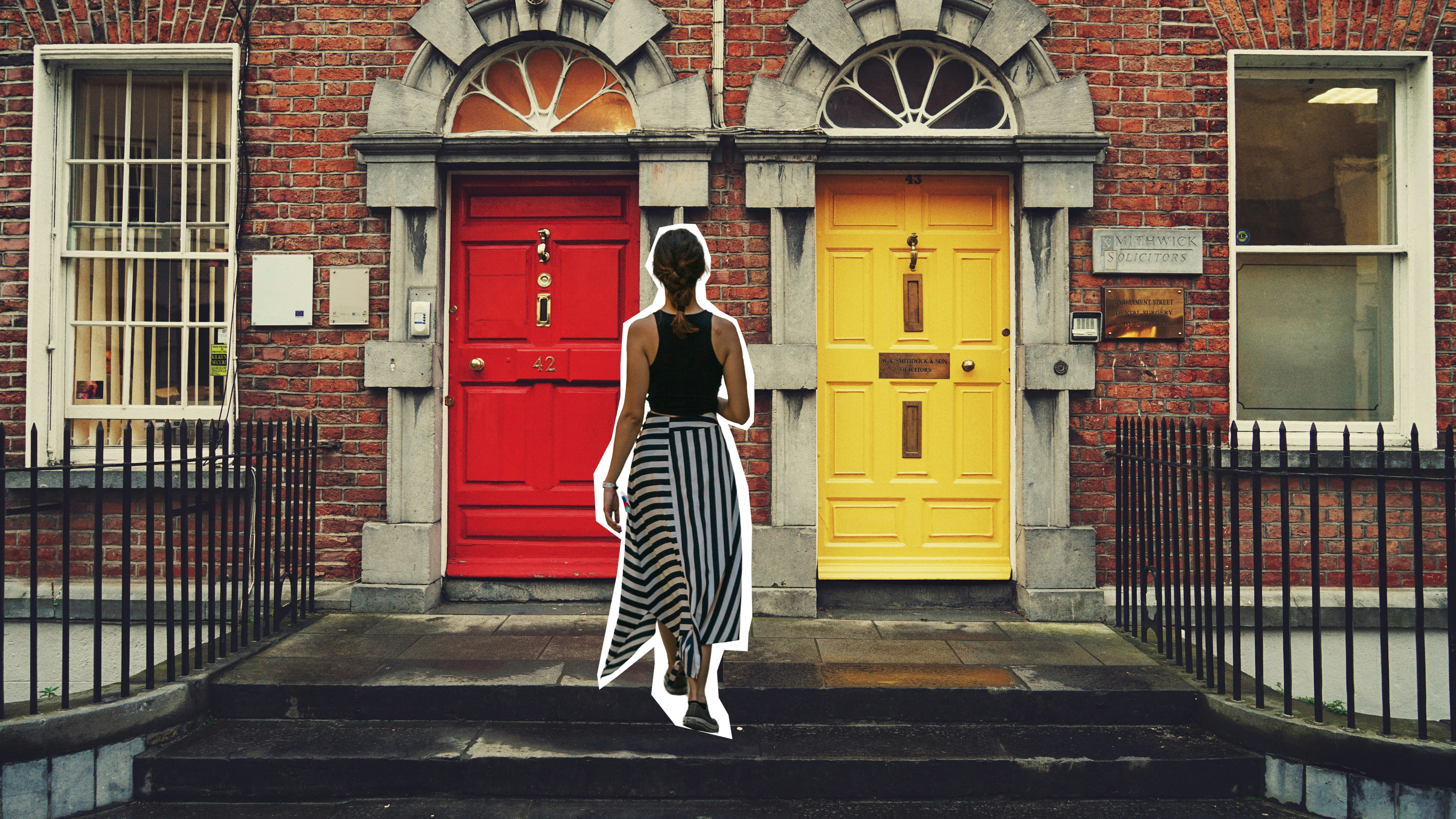 Frau vor einer Fassade mit zwei Türen