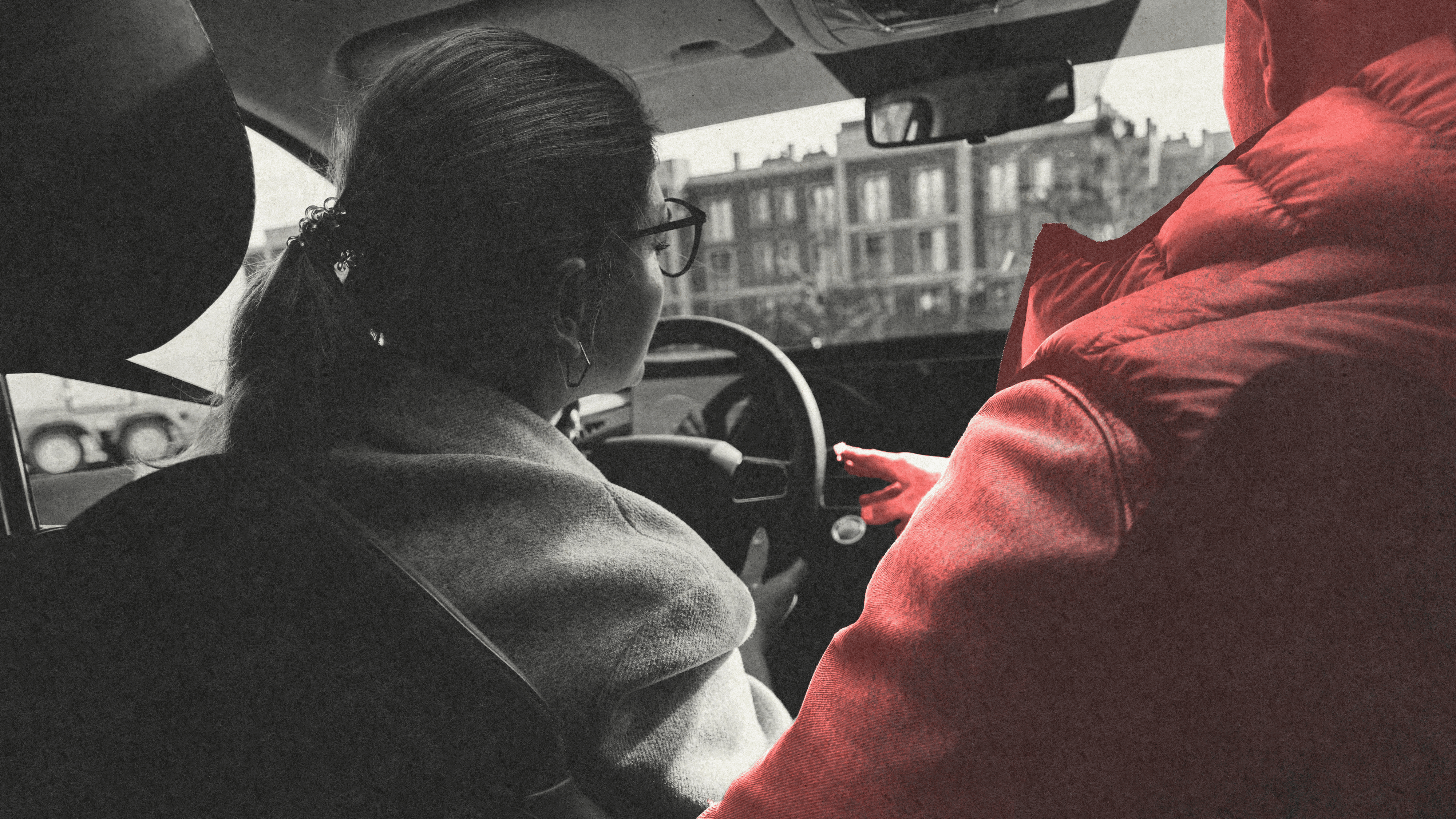 Eine Fahrschülerin sitzt neben ihrem Fahrschullehrer im Auto.