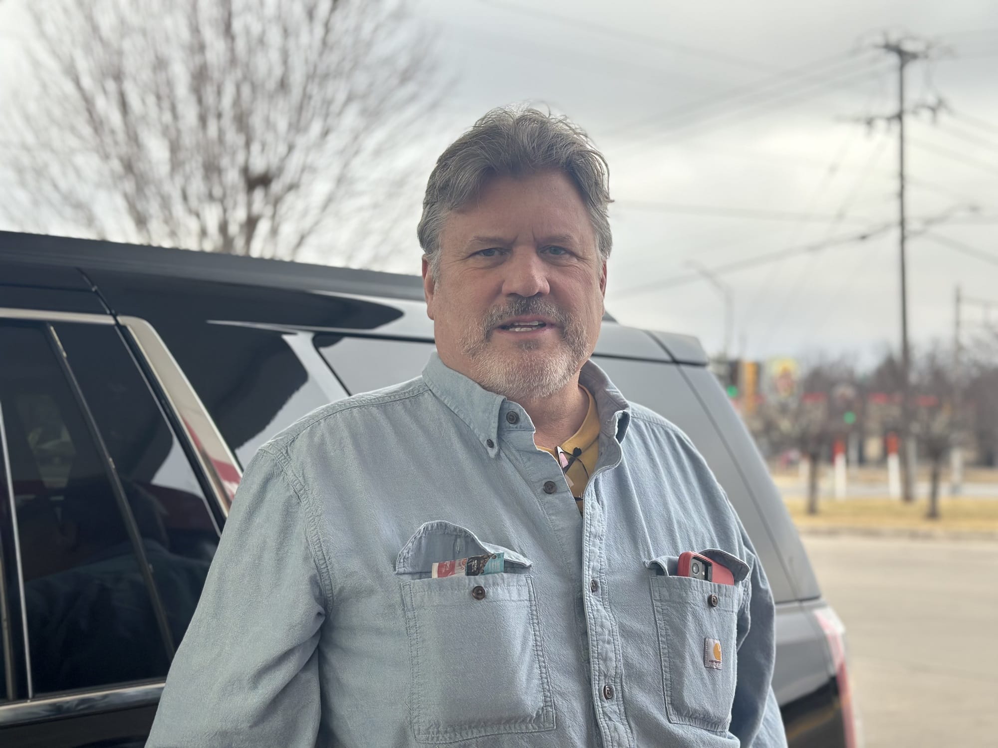 Man sieht einen Mann vor einem Auto.