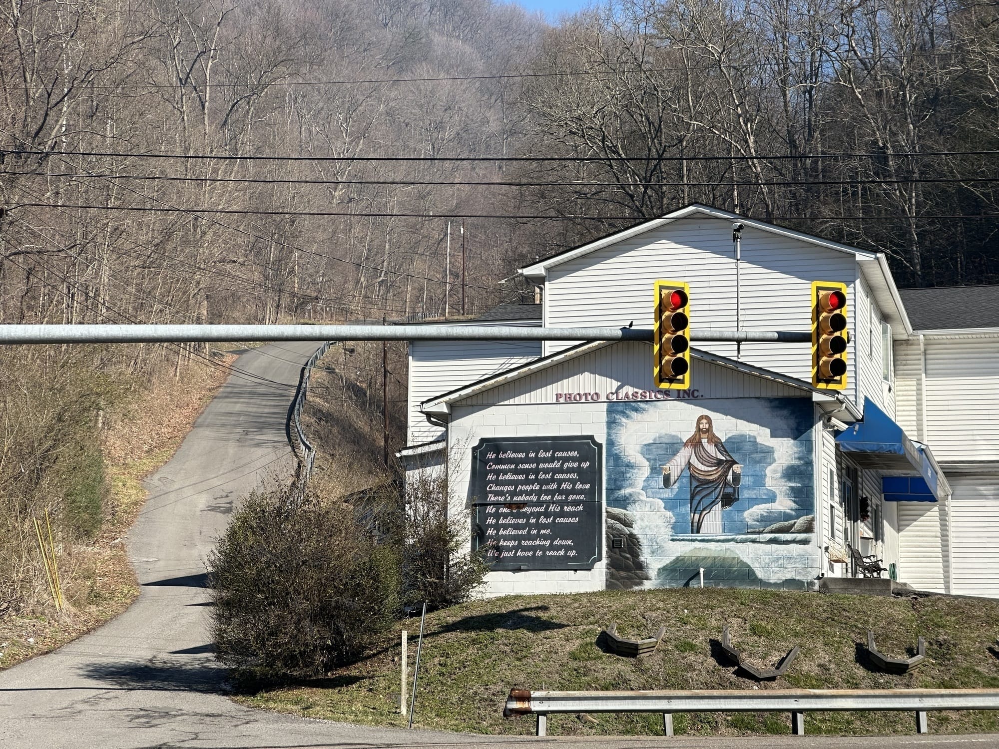 Man sieht ein weißes Haus. An einer Wand sieht man ein großes Bild von Jesus, daneben ein Gebet.