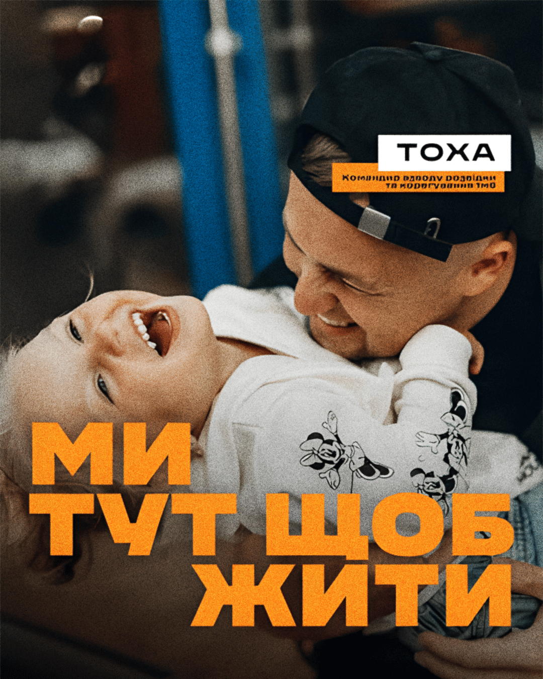 Ein Mann umarmt ein Kind, beide lachen. Darunter ein Schriftzug auf Ukrainisch.