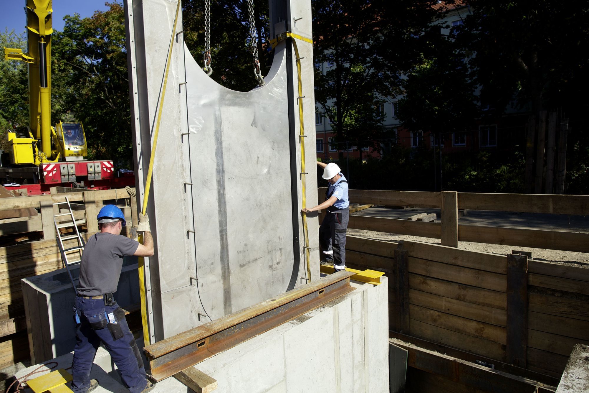 Arbeiter bauen in einen bestehenden Kanal ein Wehr ein (Storkower Straße in Berlin)