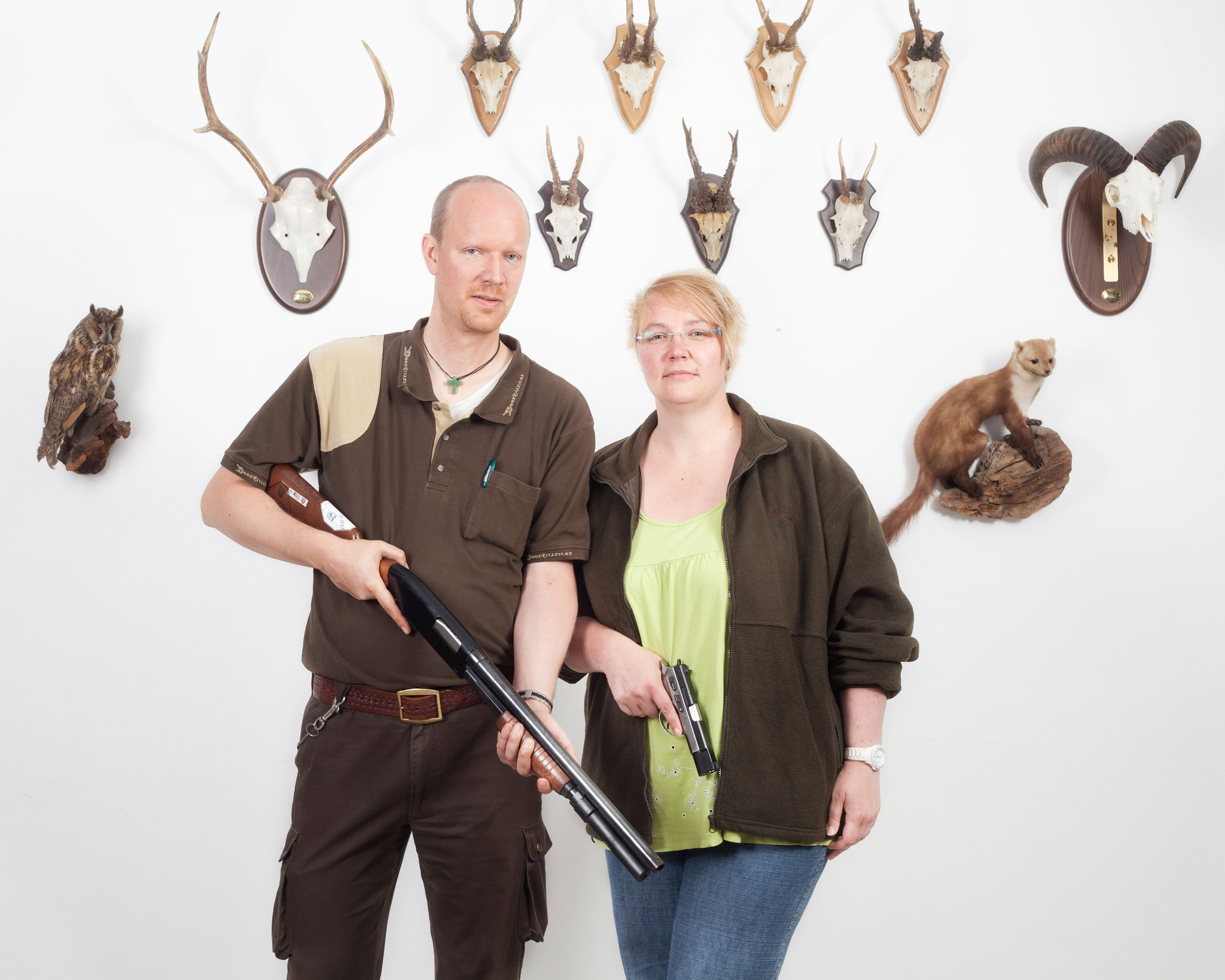 Gewehr, Pistole, Jagdtrophäen: Ein Waffenbesitzer-Paar. Die meisten in Deutschland gemeldeten Waffen werden für Sportschießen, Jagd, Nachstellen historischer Szenen oder als Sammlerobjekte genutzt.