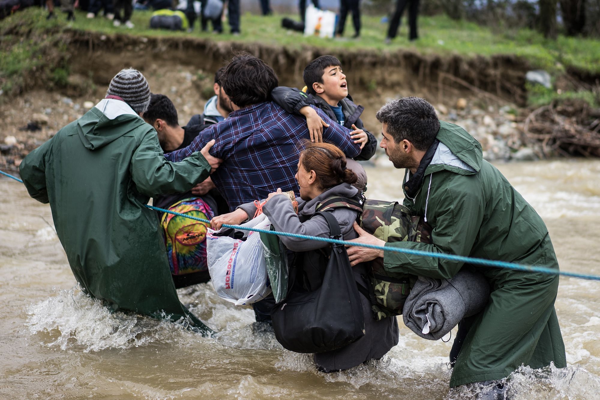 Frauen, Kinder, Alte - alle wollen über den Fluss.