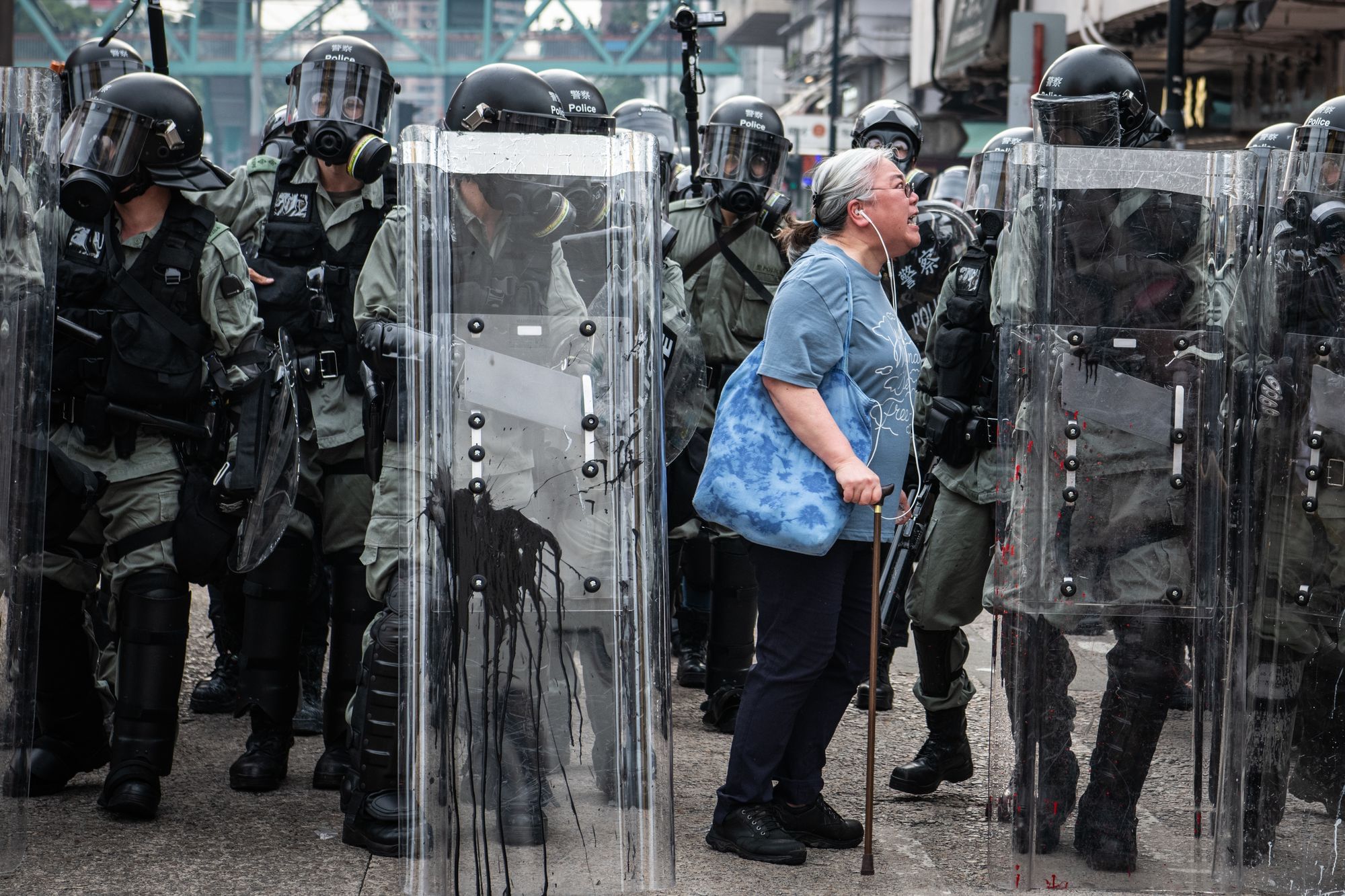 Eine Frau schreit Polizeibeamte an, als diese am 27. Juli 2019 in Hongkong auf die Proteste im Distrikt Yuen Long zusteuern.