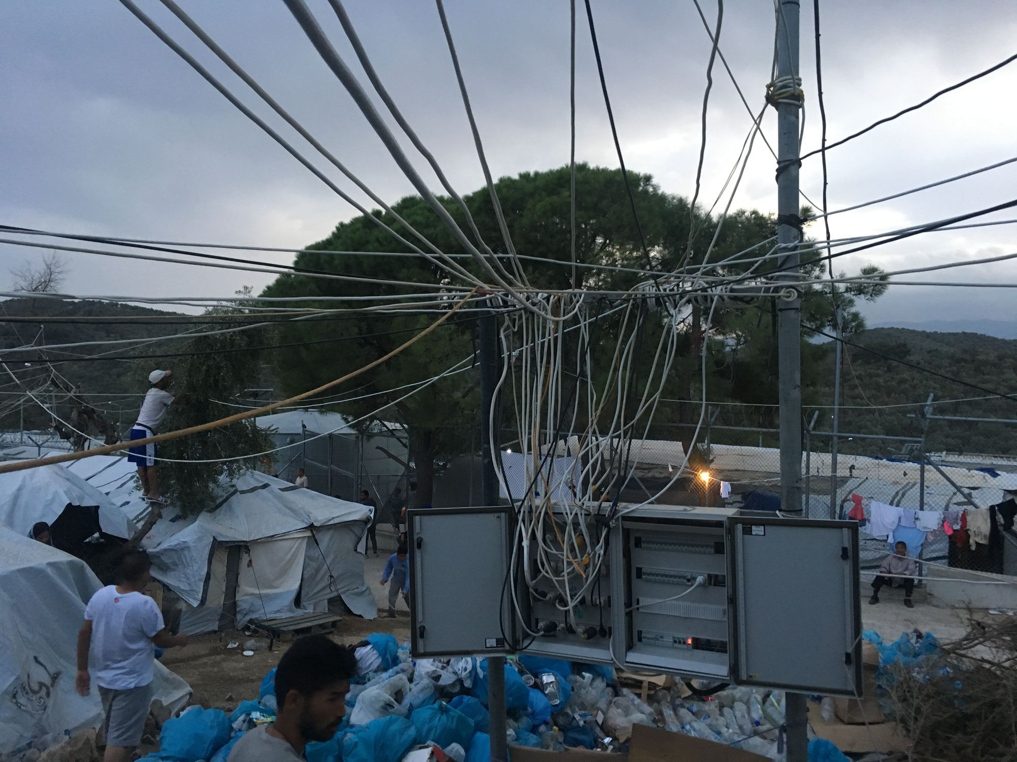 Ein Campbewohner versucht mit bloßen Händen, wieder Strom ins Lager zu bekommen.