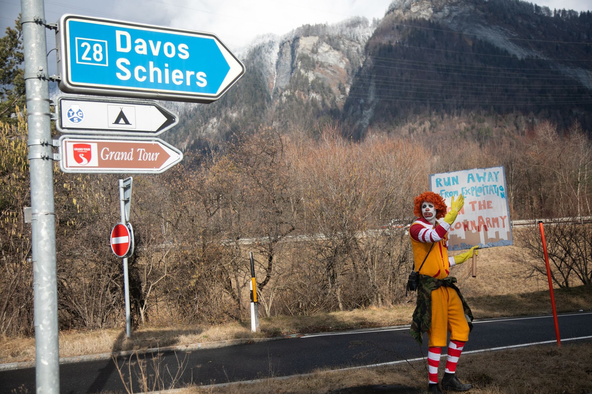 Ein Mitglied der "Clown-Armee" demonstriert an der Straße nach Davos.