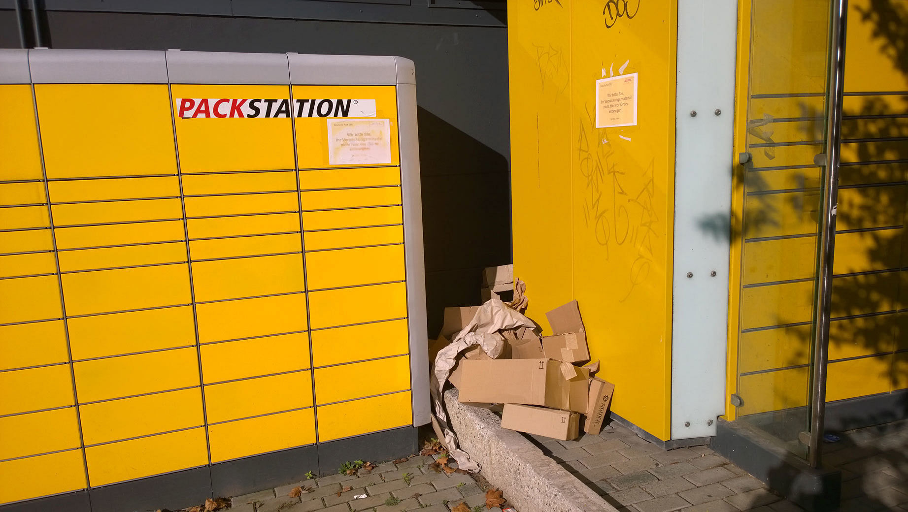 "Wir bitten Sie, Ihr Verpackungsmaterial nicht hier vor Ort zu entsorgen", steht auf den Schildern über dem Verpackungsmüll.