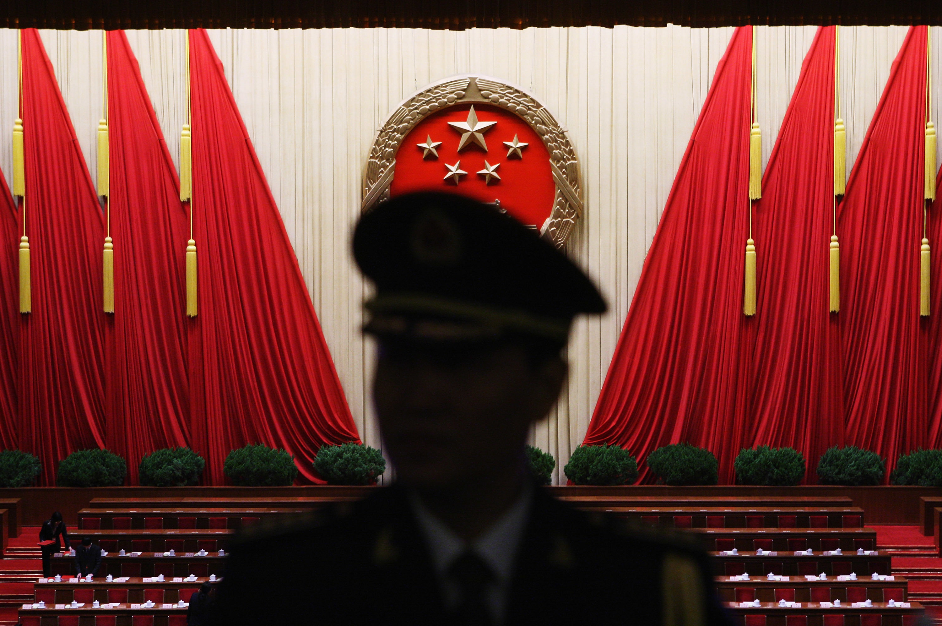 Schattenriss eines chinesischen Soldatens vor großen roten Tüchern.