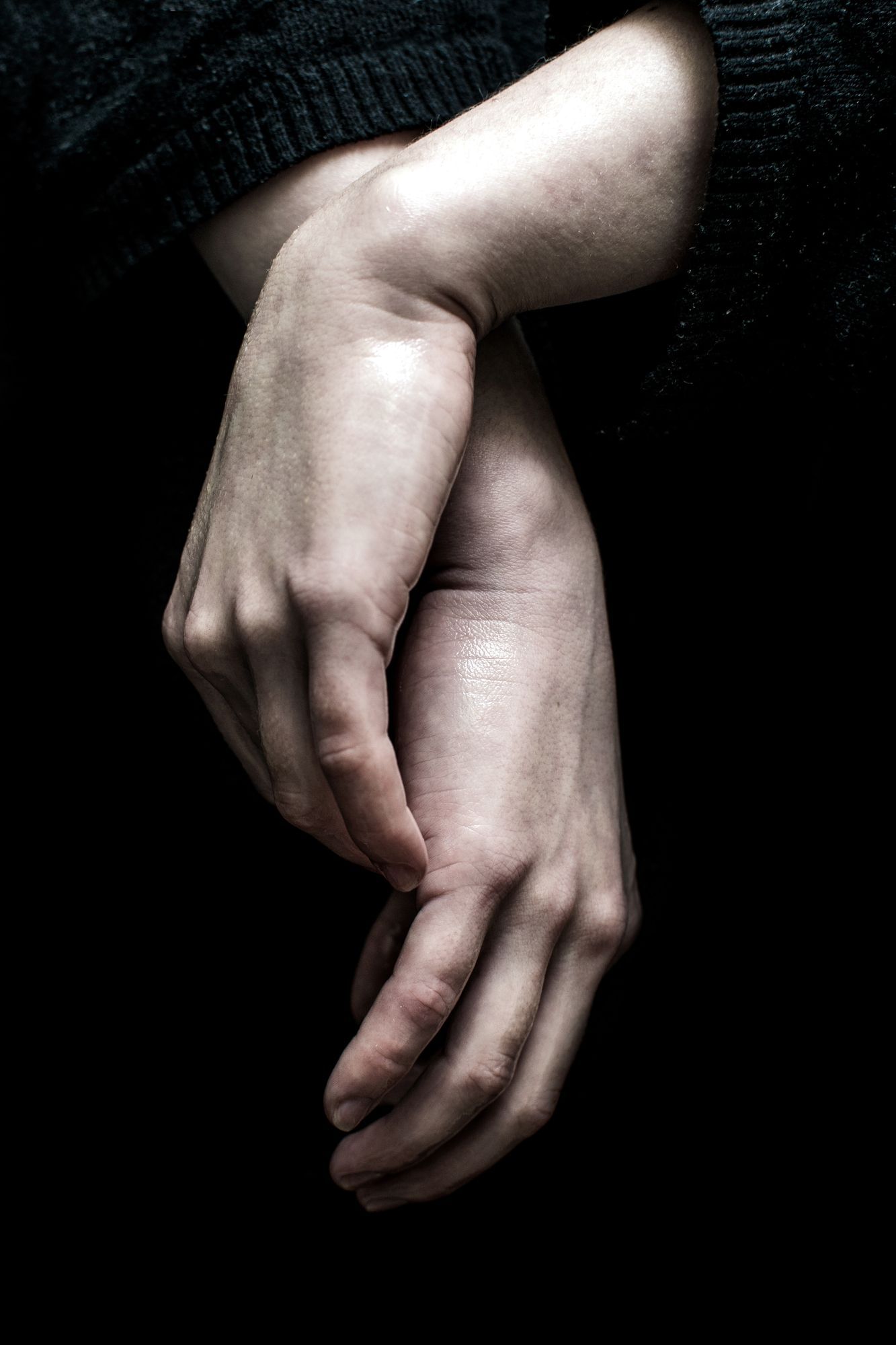 Hand einer junge Frau isoliert auf dunklem Hintergrund