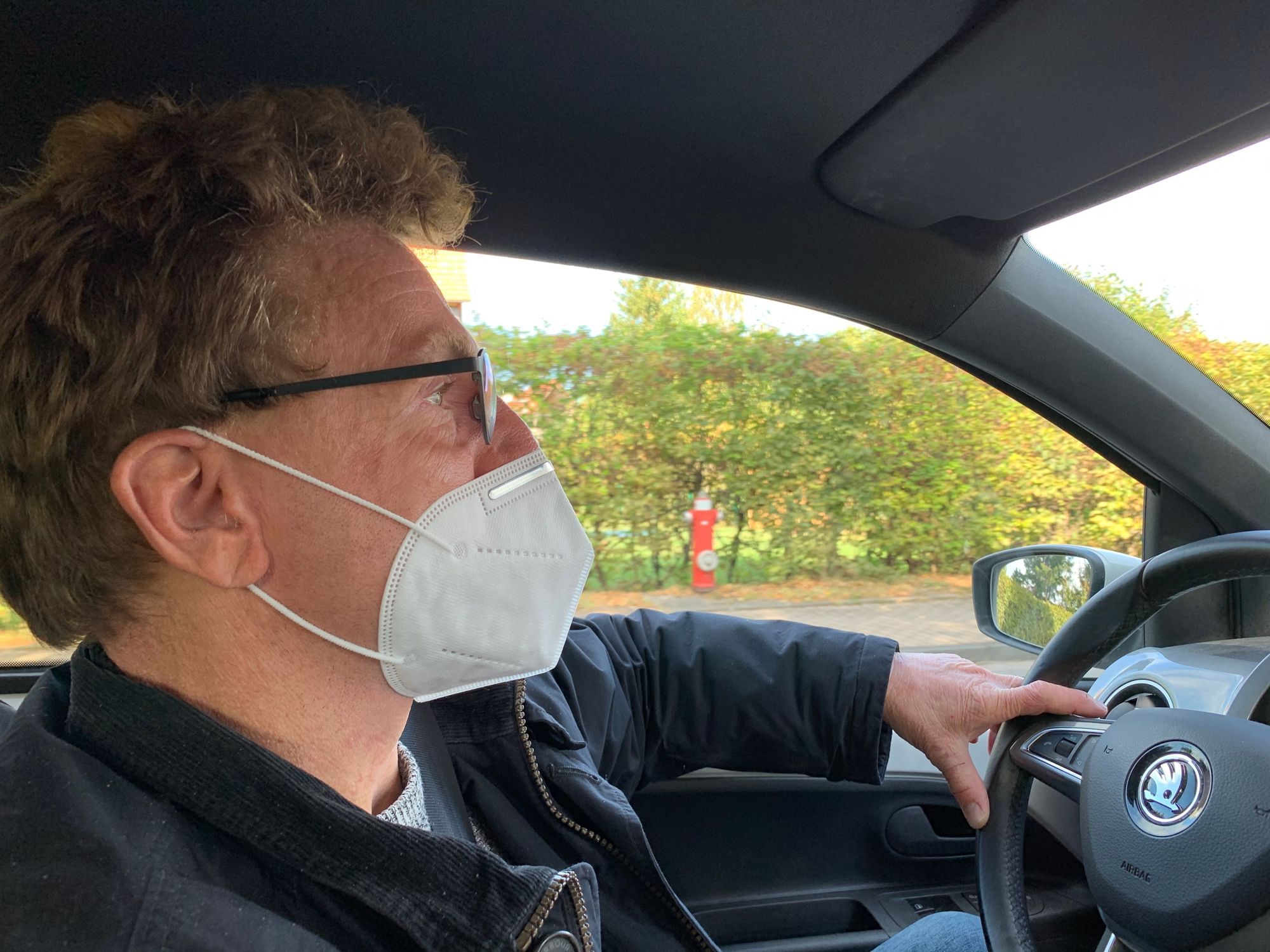 Das Bild zeigt Volker Barths Gesicht im Profil beim Autofahren. Er trägt eine FFP2-Maske.