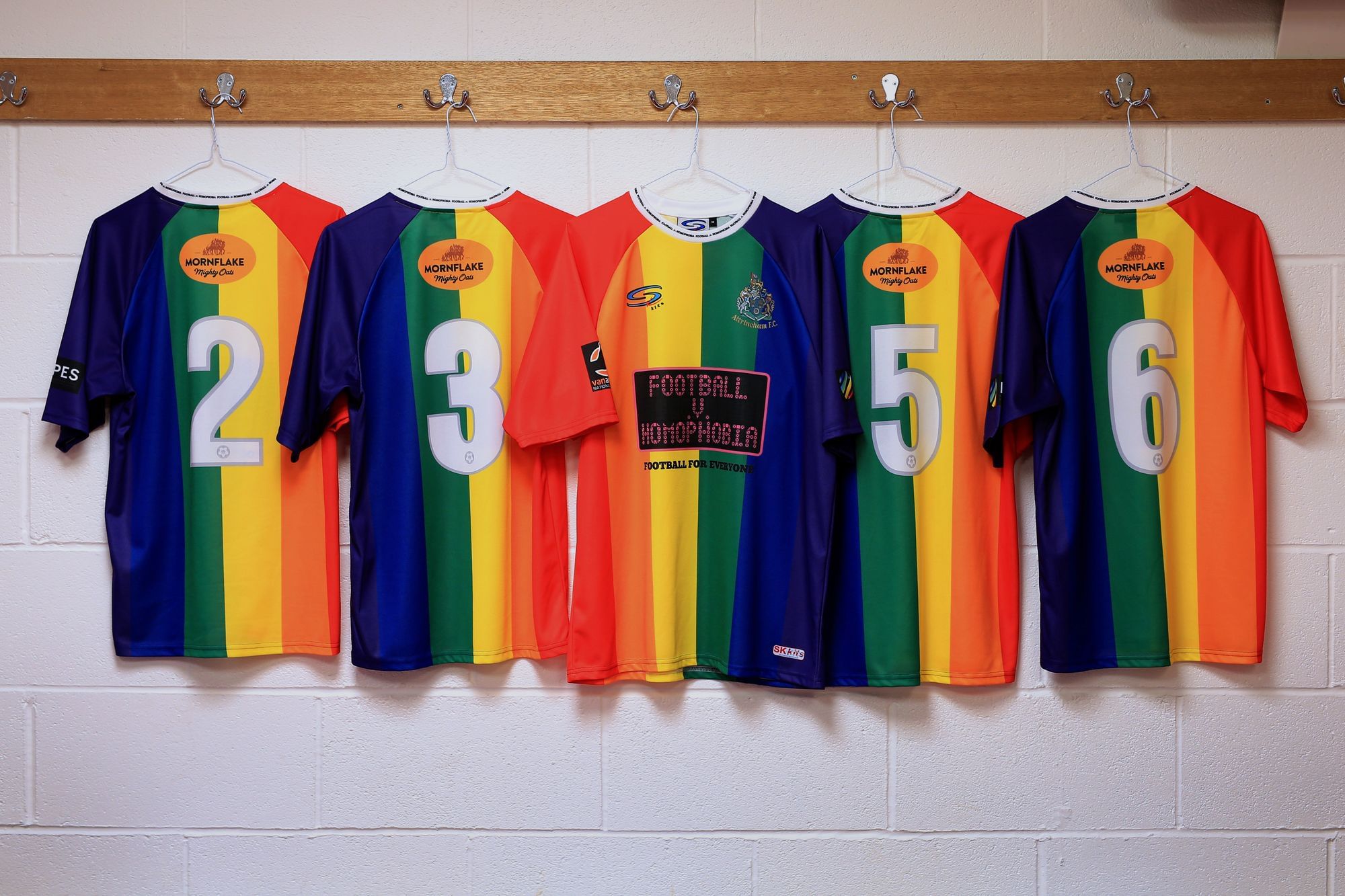 In einer Umkleidekabine hängen Regenbogen-Shirts mit der Botschaft "Fußball gegen Homophobie" zur Unterstützung der LGBT-Community.