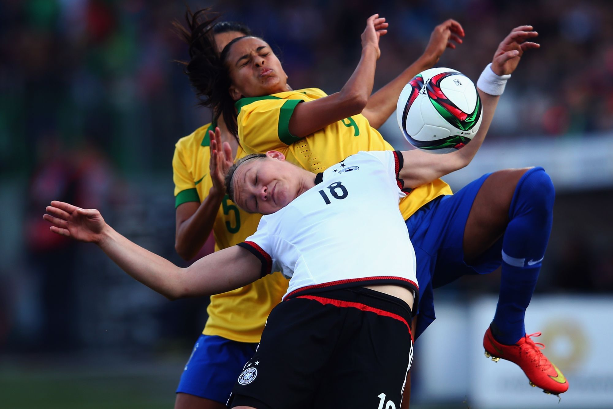 Alexandra Popp (im Vordergrund) im Sprung unterhalb von Andressa Alves versuchen den Ball vor ihnen zu erreichen.