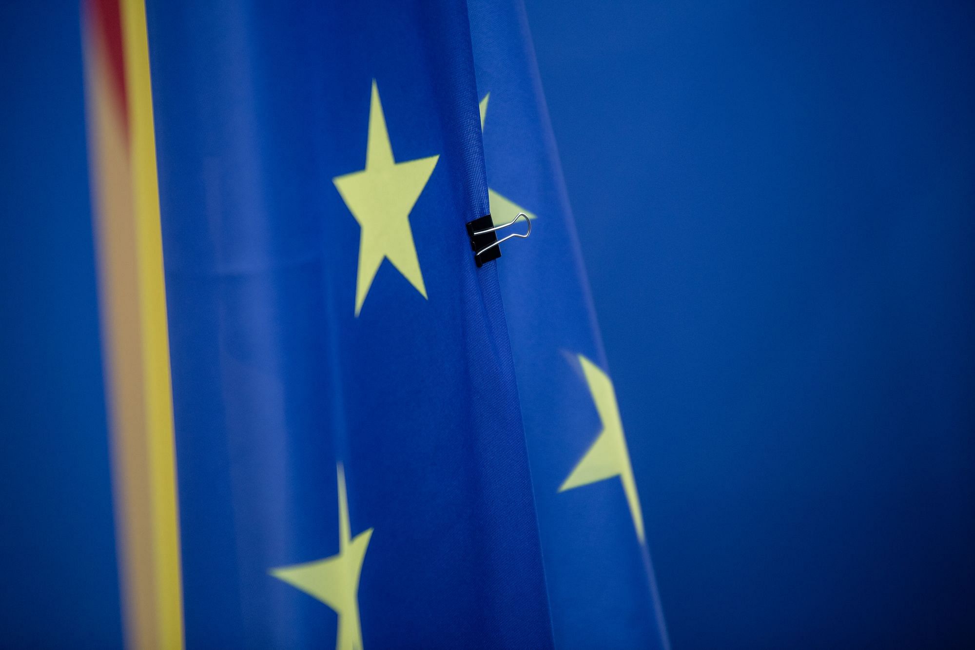 Eine EU Flagge mit Aktenklammer arretiert.